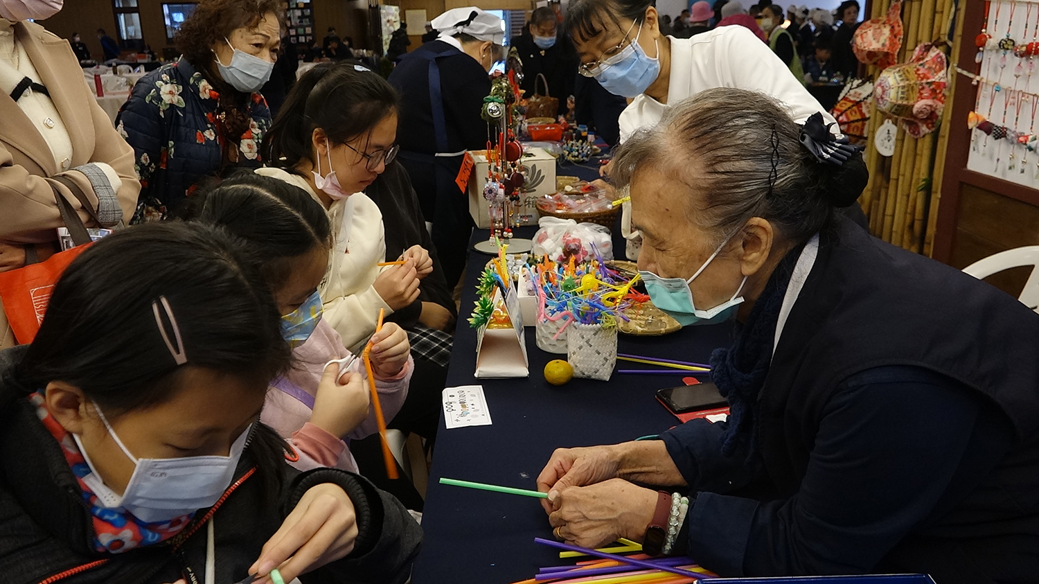 「巧手工坊環保創意DIY」由志工現場進行「毛毛蟲」教作。