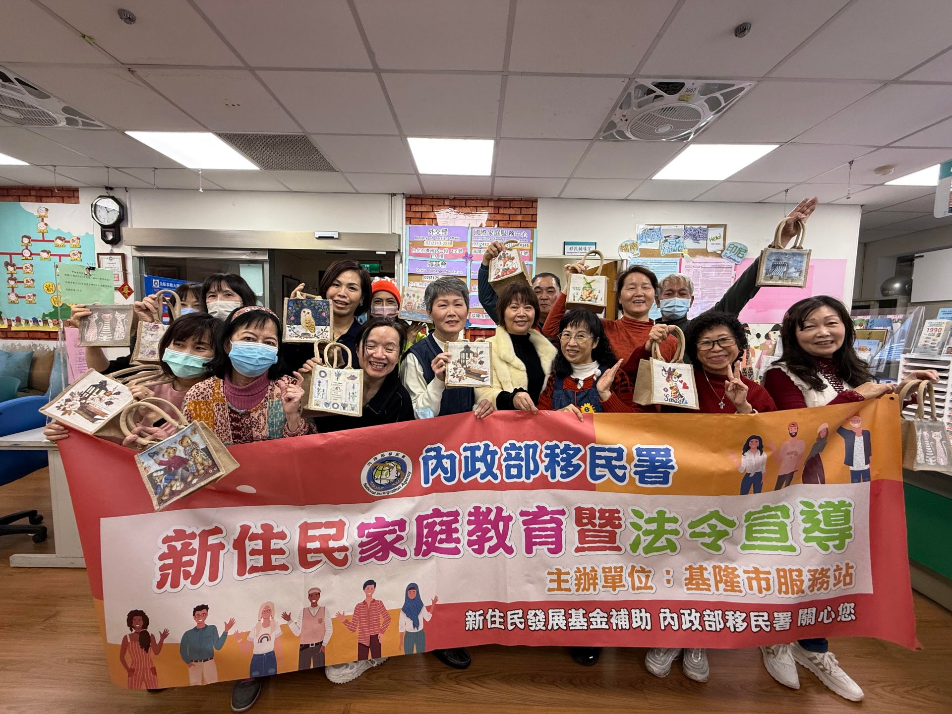 全體新住民家庭成員手持自己的蝶谷巴特麻布袋作品合影