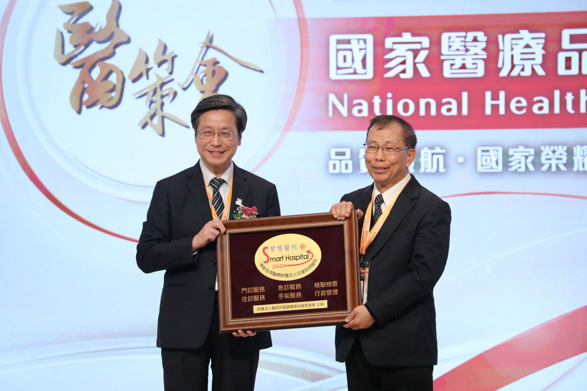 花蓮慈濟醫院在第25屆國家醫療品質獎(NHQA)的中,獲頒「智慧醫院全機構標章」殊榮,並由醫策會董事長張上淳(左)頒發獎項,由吳彬安副院長(左)代表受獎。