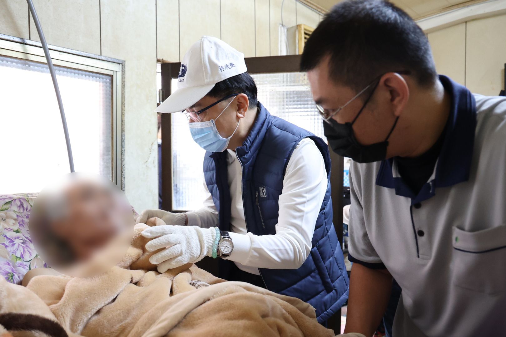林欣榮院長(中)關懷中風病人吳先生(左),右為花蓮慈院照顧服務員。