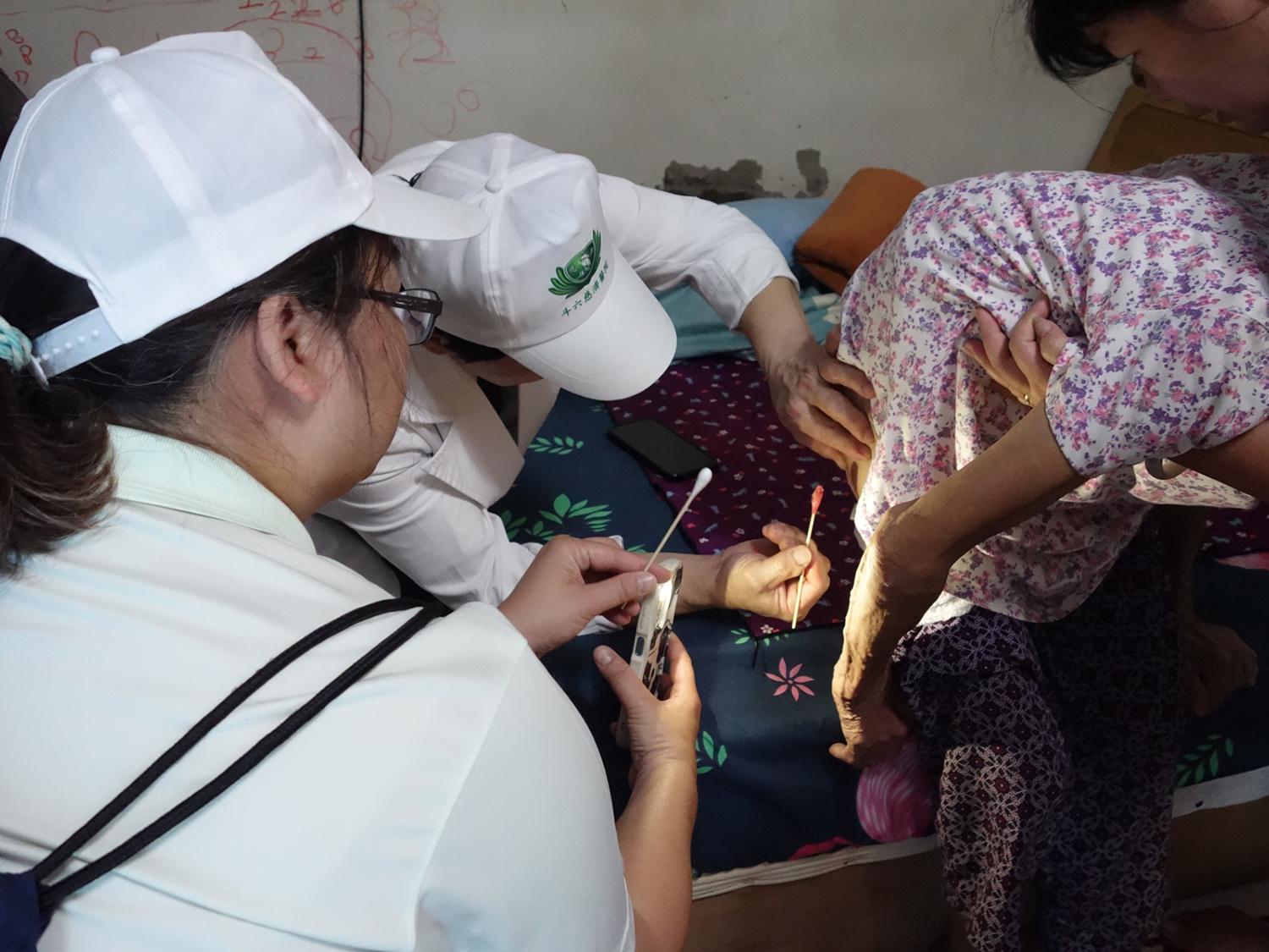 簡瑞騰副院長關懷受災戶時,協助一位90歲阿嬤褥瘡清創。