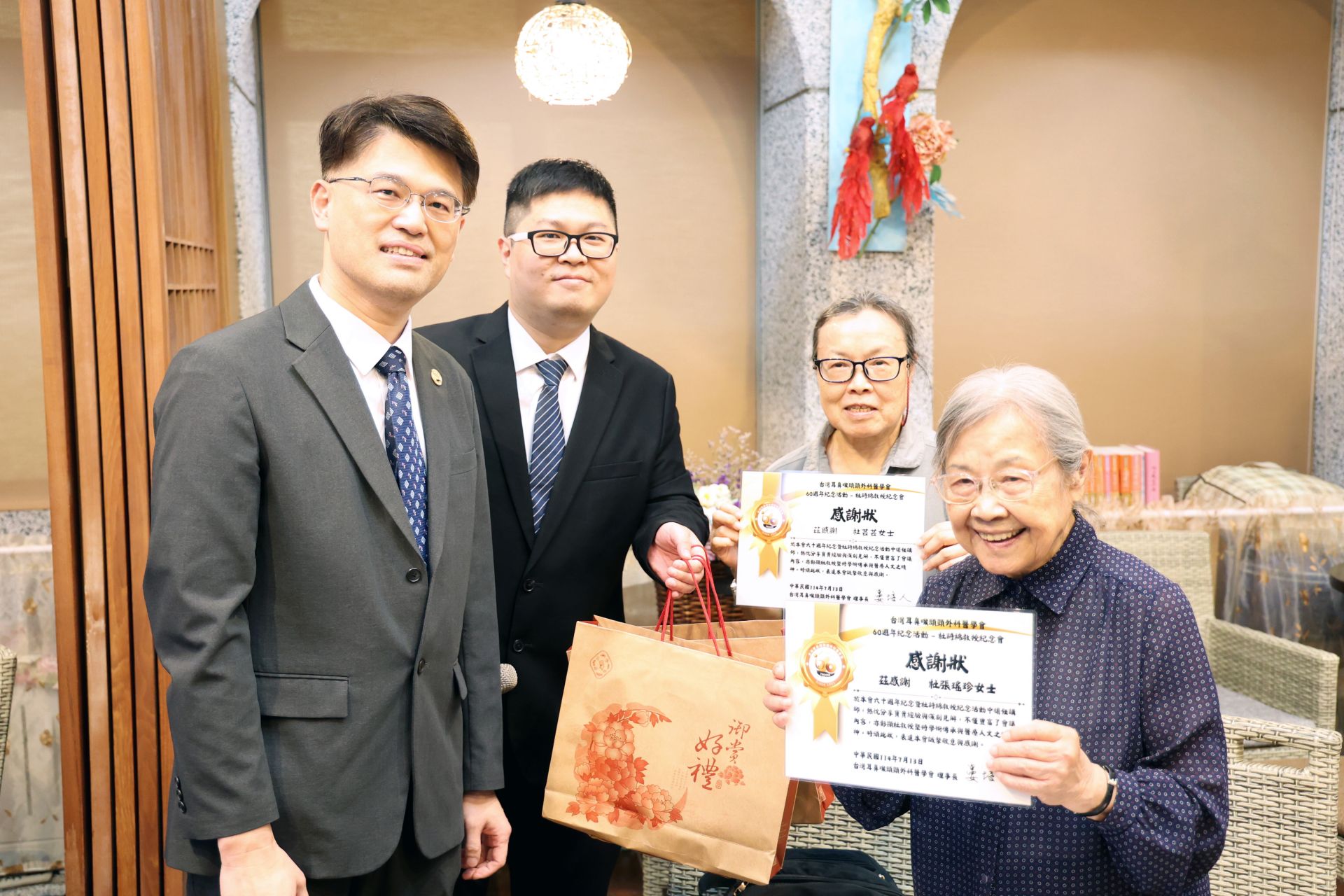 台灣耳鼻喉頭頸外科醫學會副祕書長廖立人(左)頒發感謝狀予杜詩綿院長的夫人張瑤珍女士(右一)及女兒杜芸芸(右二),表達對杜院長的感恩與思念。