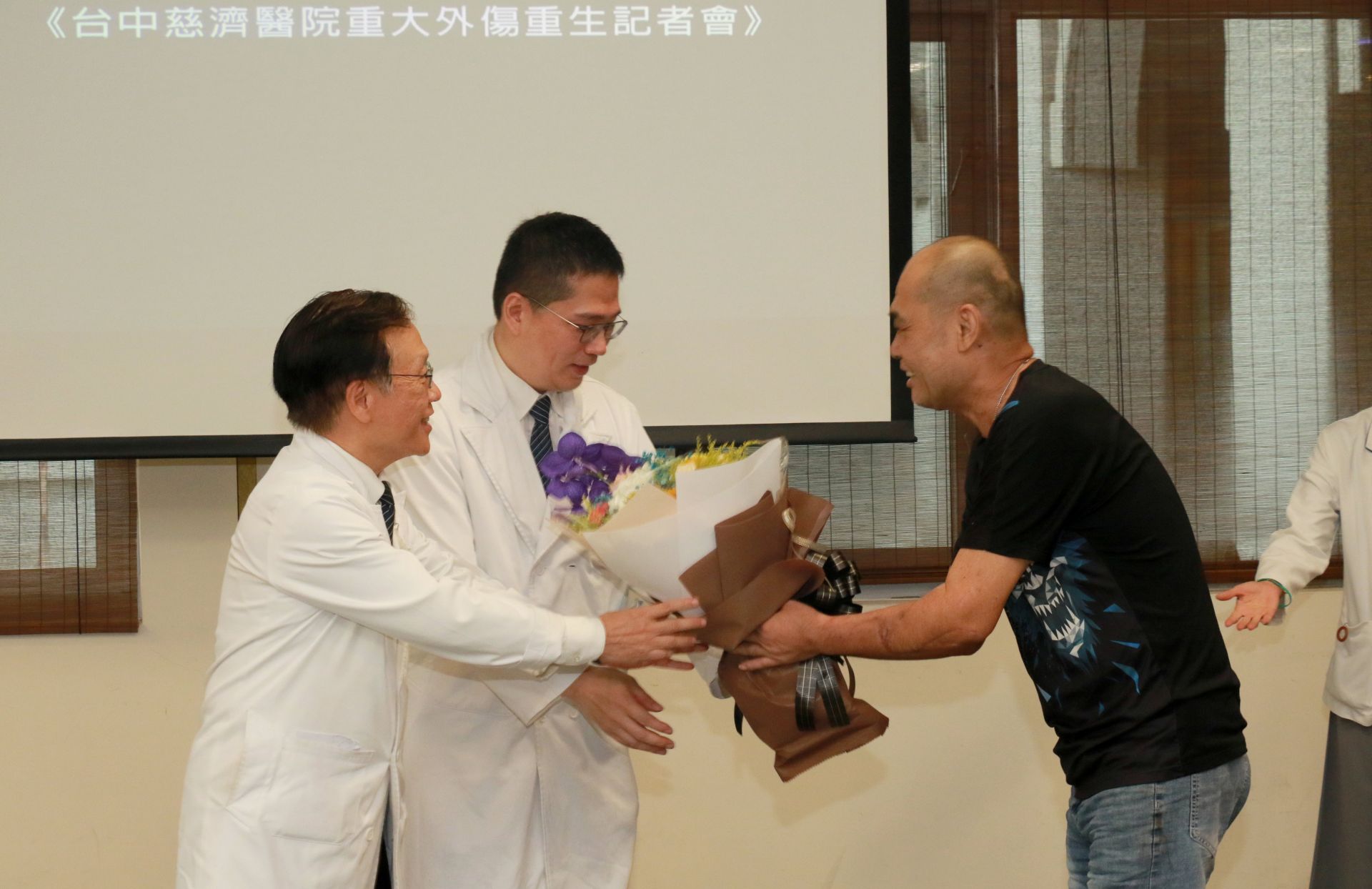 胡先生致贈花束感謝台中慈濟醫療團隊,由簡守信院長(左)、一般外科醫師高國堯(左二)代表接受。