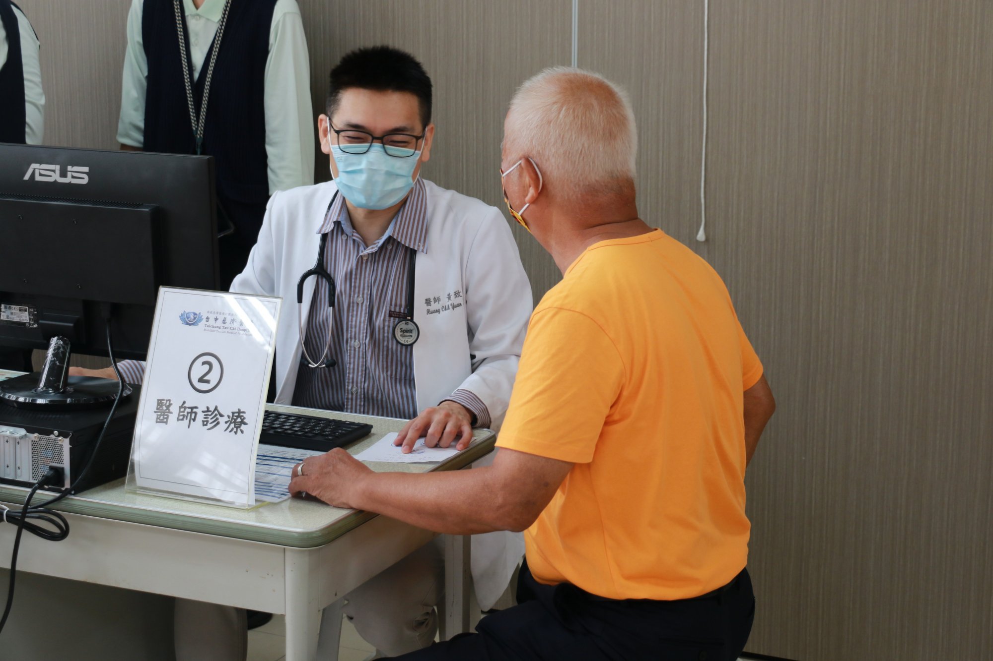 (左)台中慈濟醫院家庭醫學科黃致遠醫師,為年長居民細心看診。