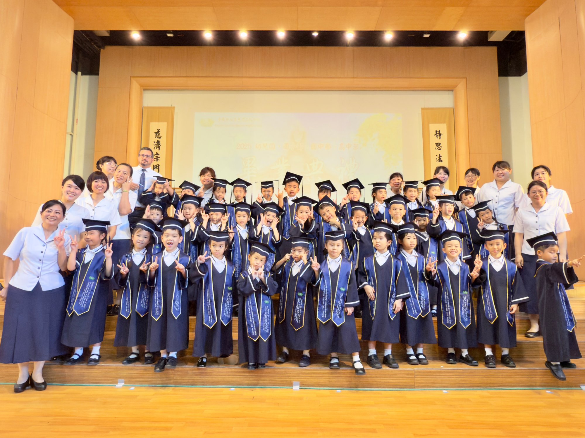 幼兒園畢業生身穿慈濟藍學士袍、披垂榮譽帶，象徵學有所成