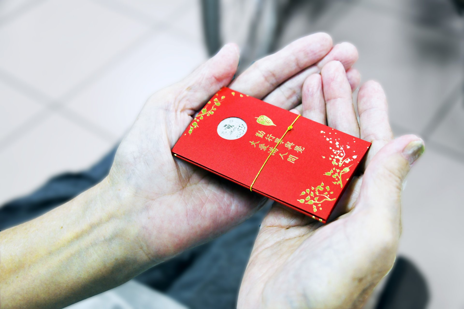 鄭主任特別向人文室申請了證嚴上人對大眾的祝福─「福慧紅包」。他親手將這些象徵平安與祝福的紅包,送到長者們的手中。