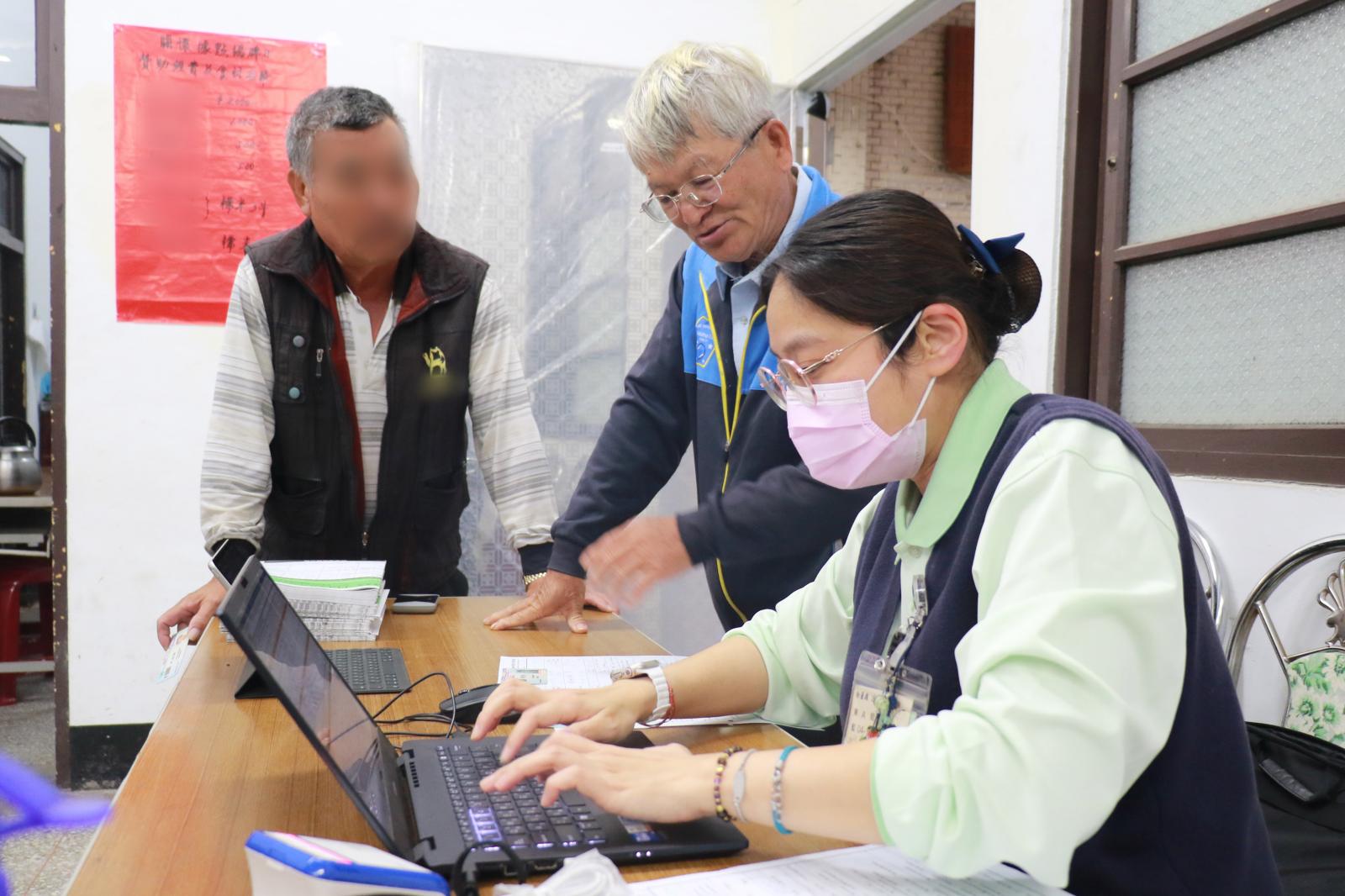 登入掛號資料時古永源校長(圖右二)熱情招呼居民。
