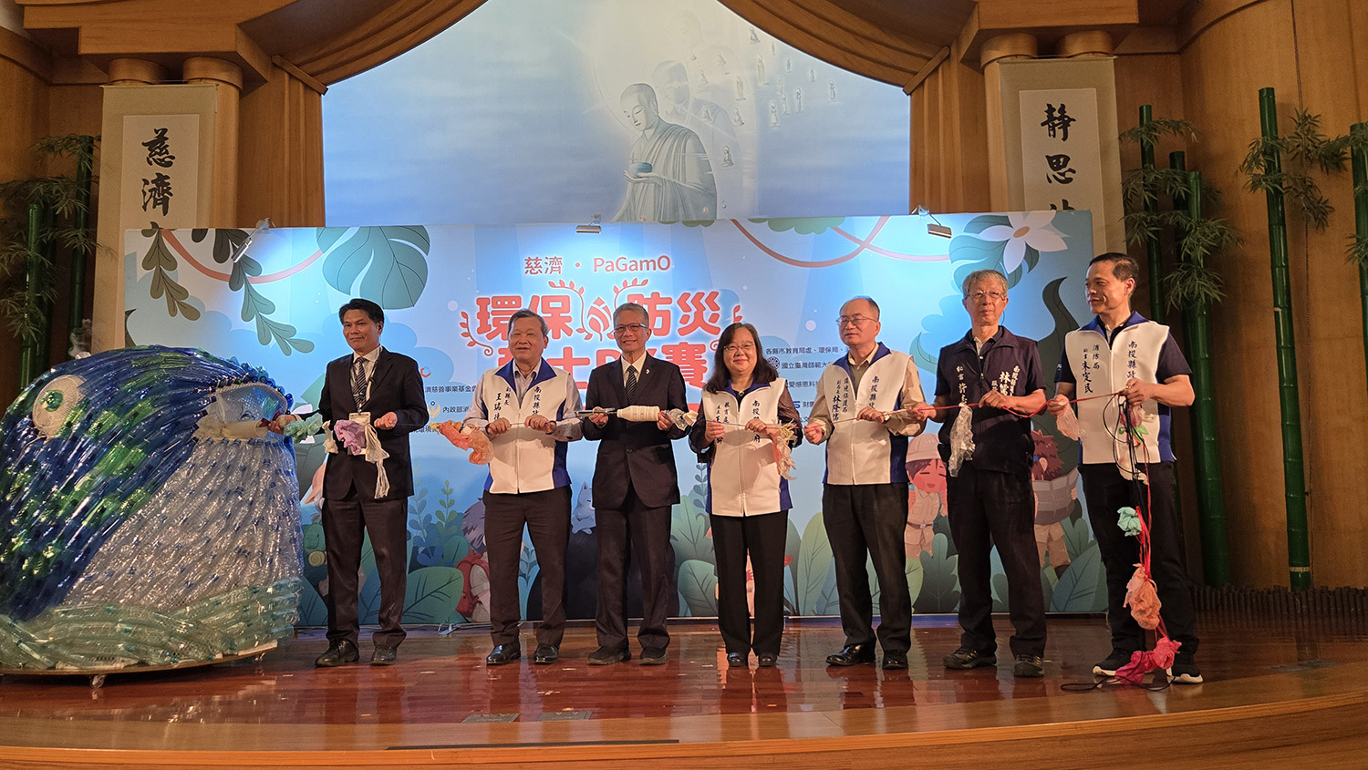 與會貴賓從寶特瓶製成的鯨魚口中拉出許多垃圾救助海洋生態。
