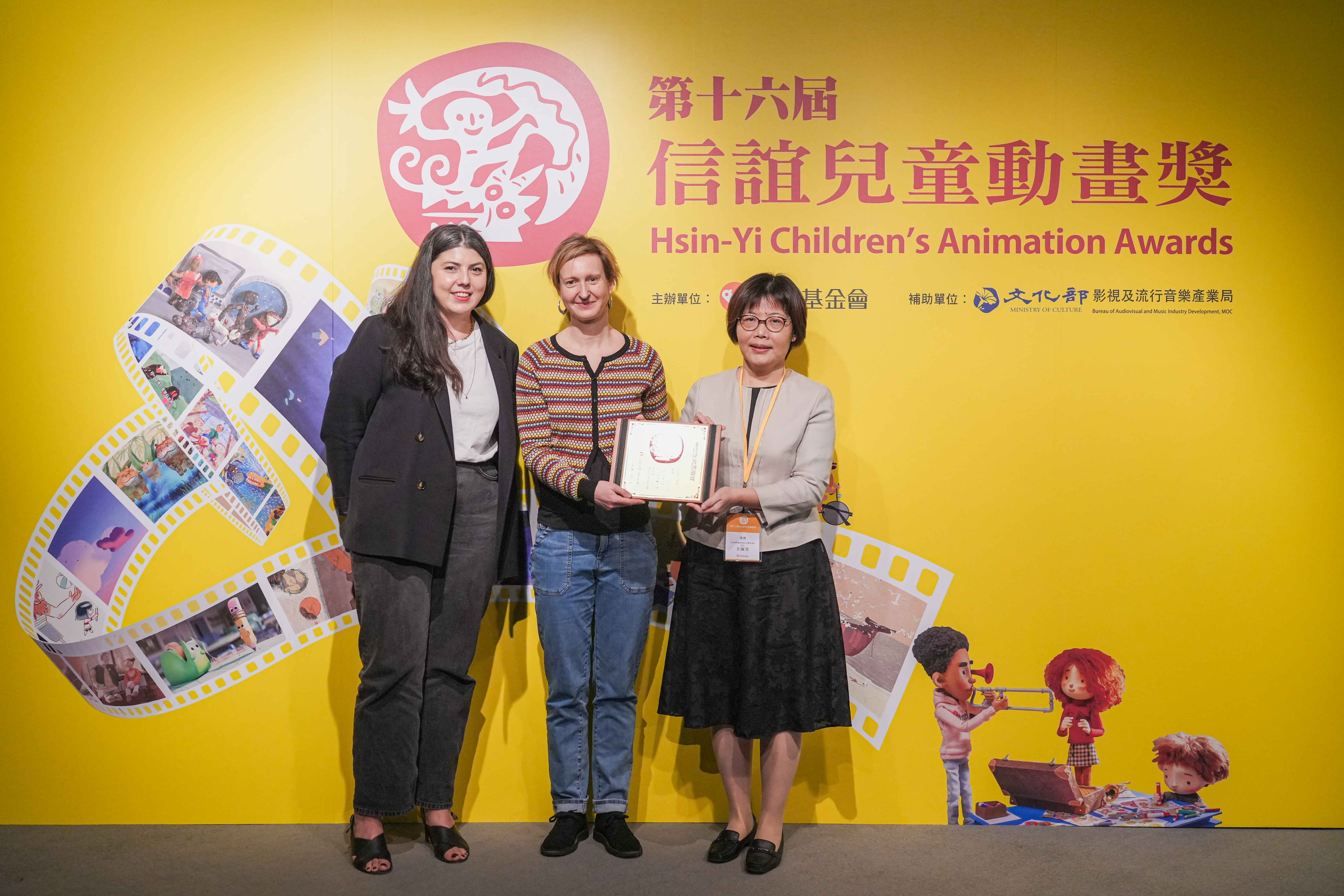 文化部王淑芳局長(右)與法國在台協會 Ana Villa 影視專員(左)共同頒發兒童票選第一名給法國導演蘇菲．羅茲(中)(信誼提供)。、