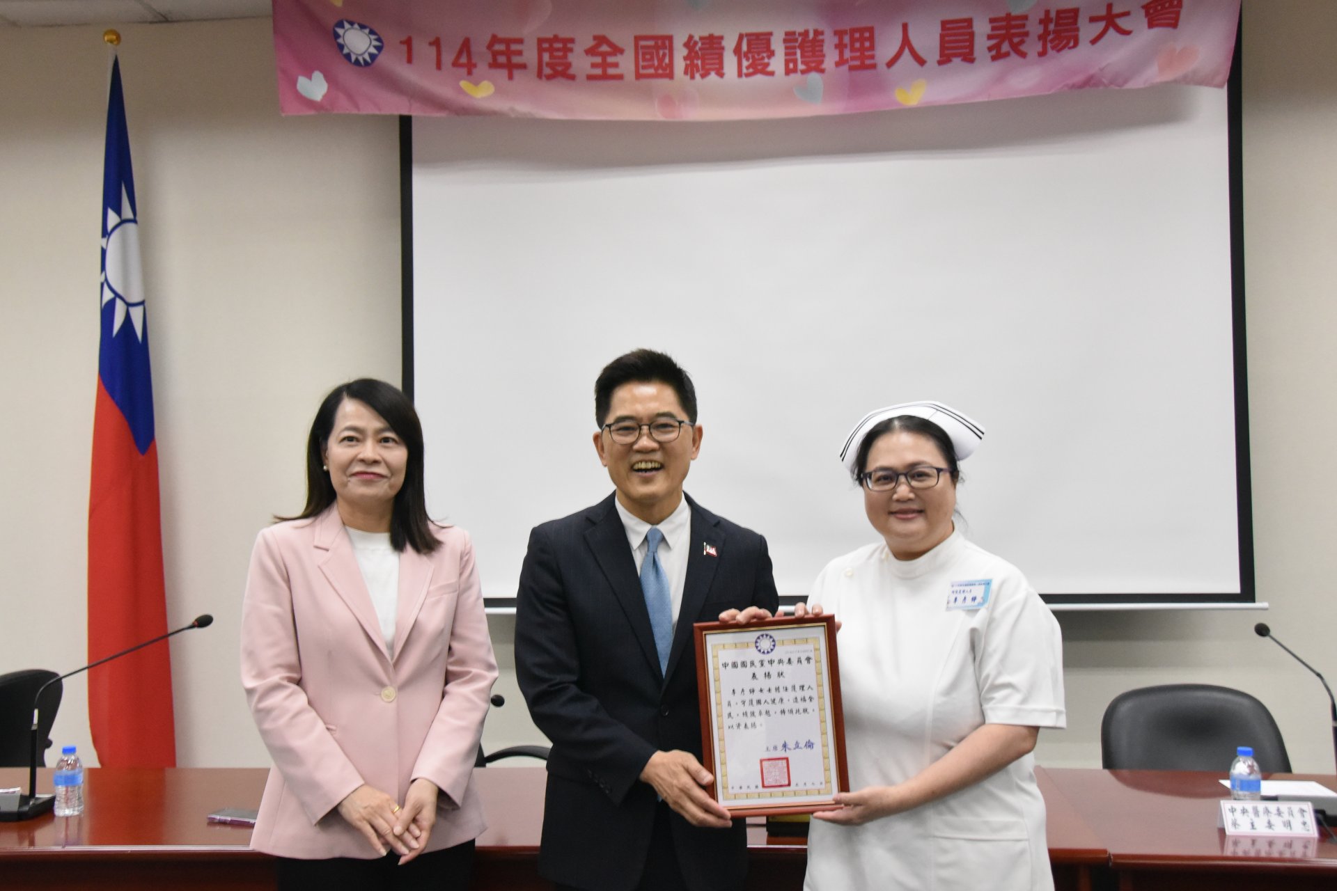 經護理師公會全聯會推薦,花蓮慈濟醫院護理部督導李彥錚(右)獲國民黨全國績優護理人員表揚。頒獎人為國民黨秘書長黃健庭(中)。