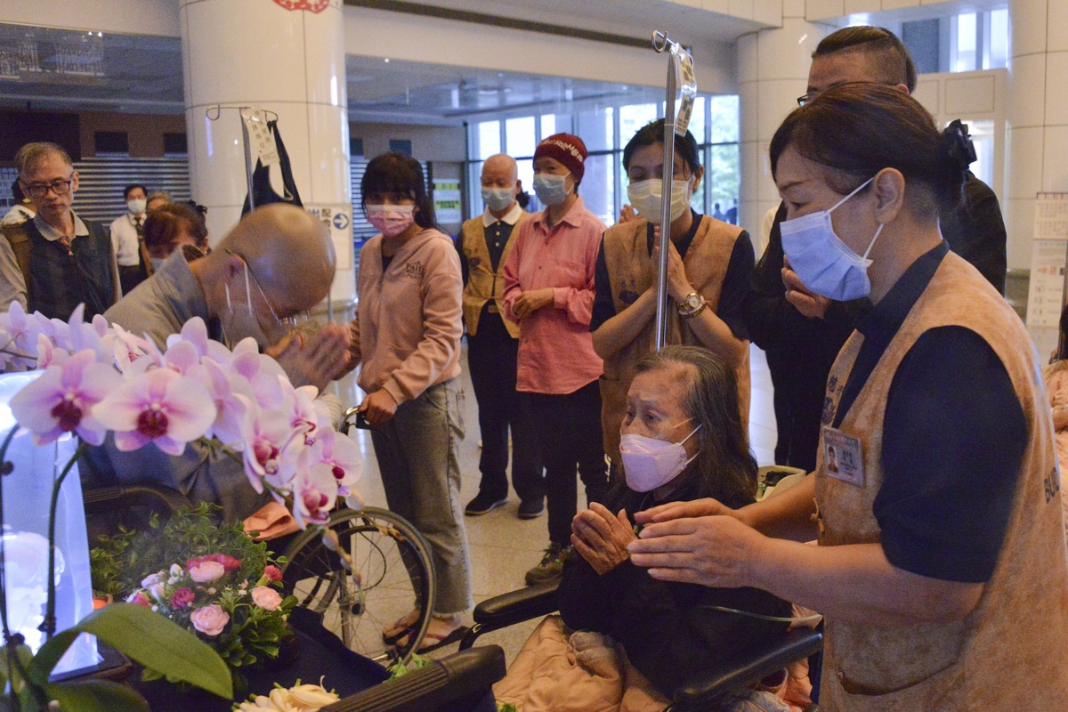 因雨勢較大,前來現場的住院大德皆改以在醫院大廳進行浴佛,圖為81歲的兵李奶奶。