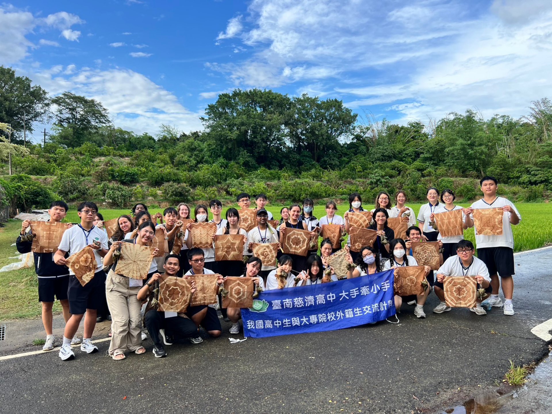 雨後放晴,臺南慈中師生與成大外籍生帶著親手染製的作品拍照留念。