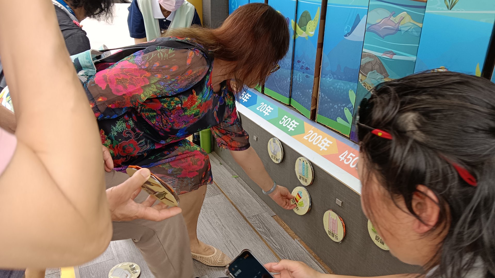 來到「現在的地球」這一站,長者依物品分解時間從一年內、五年……四百五十年、千年擺放。學習過後,長者驚訝說到玻璃瓶要一千年才能分解。