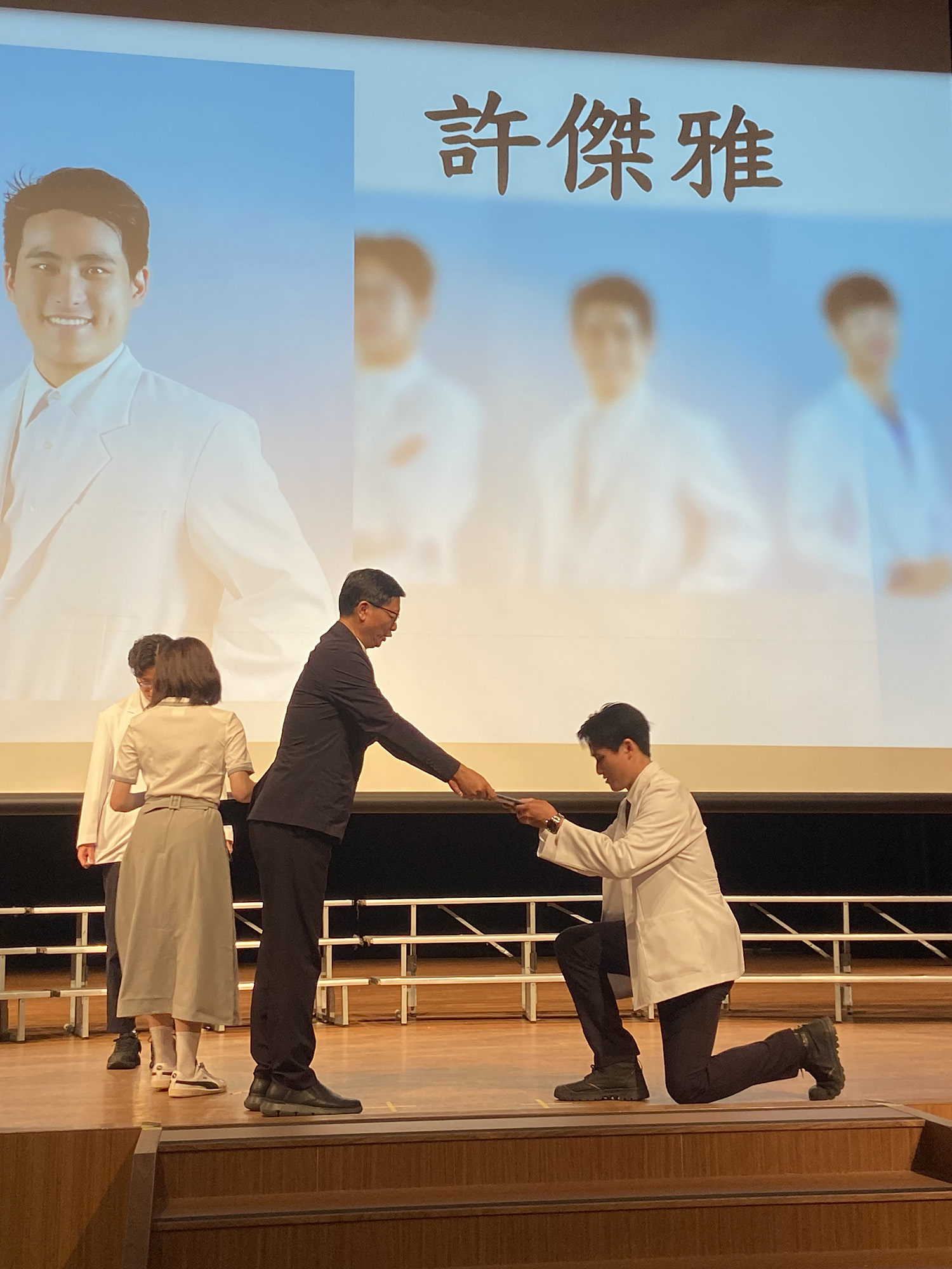 由師長親自為學生穿上白袍,授予名牌和證書。