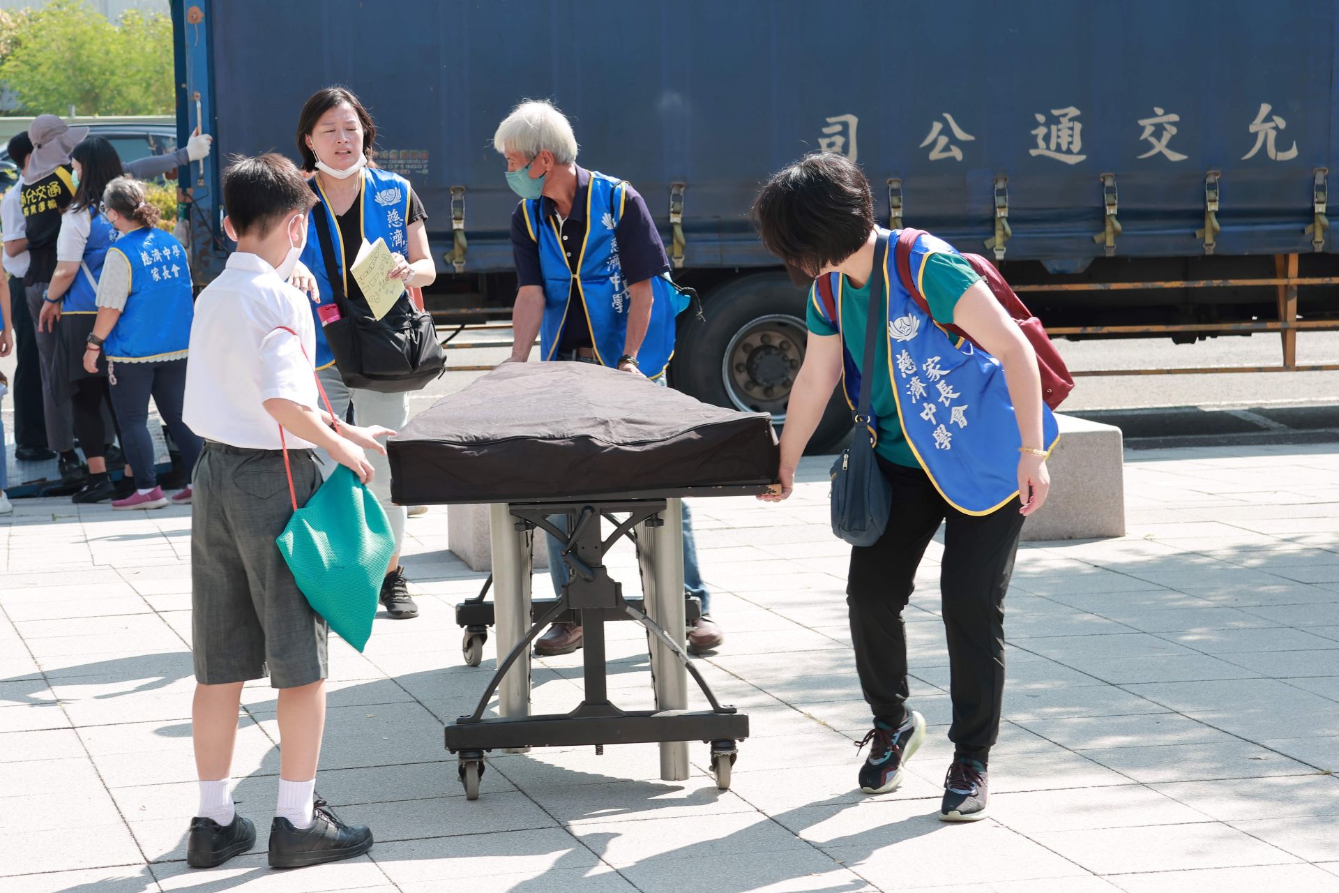 家長志工與孩子們合力搬運樂器,展現慈小親師生一條心的團隊精神。