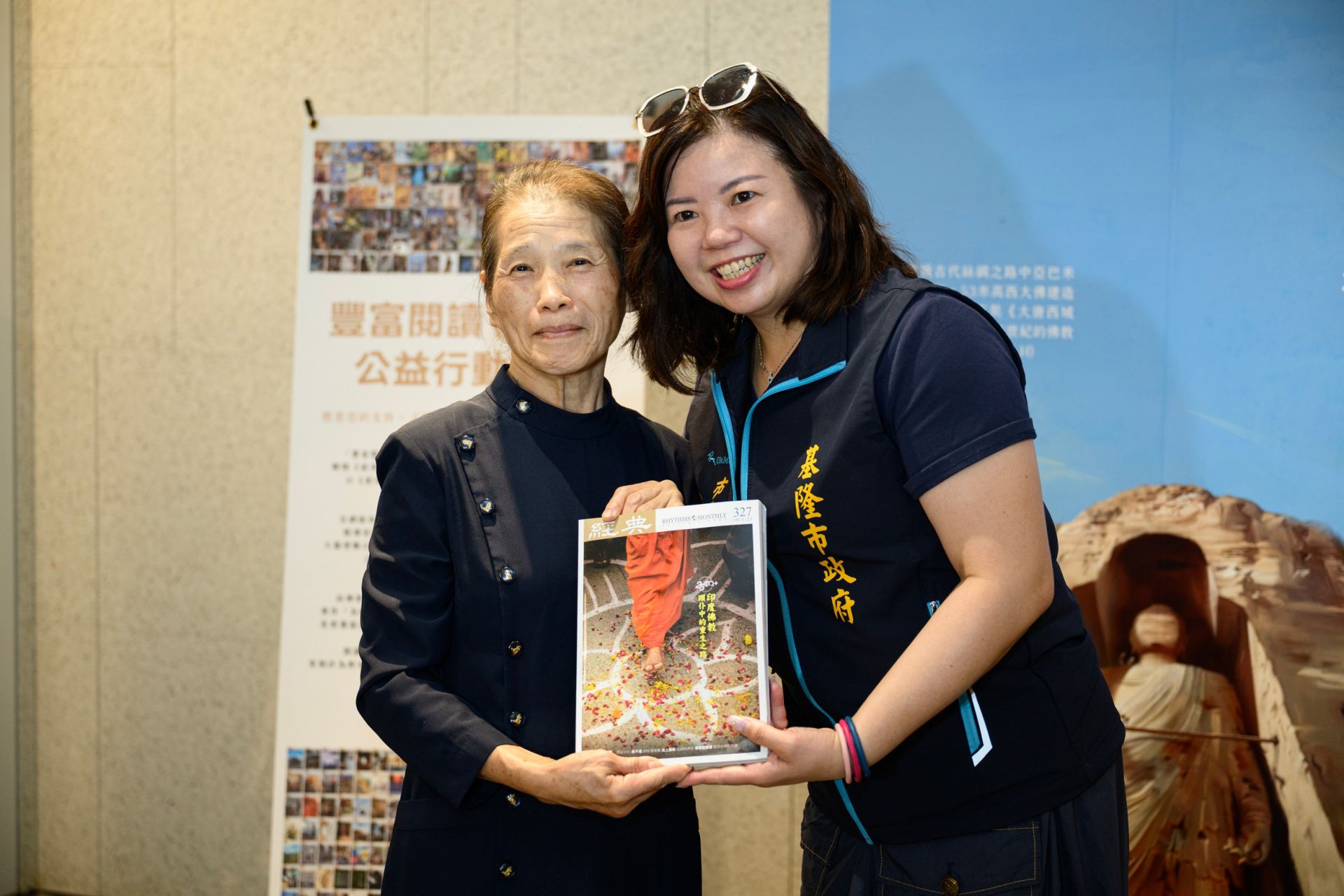 在地資深慈濟志工代表贈書給基隆市政府代表陳予旋秘書(右)。