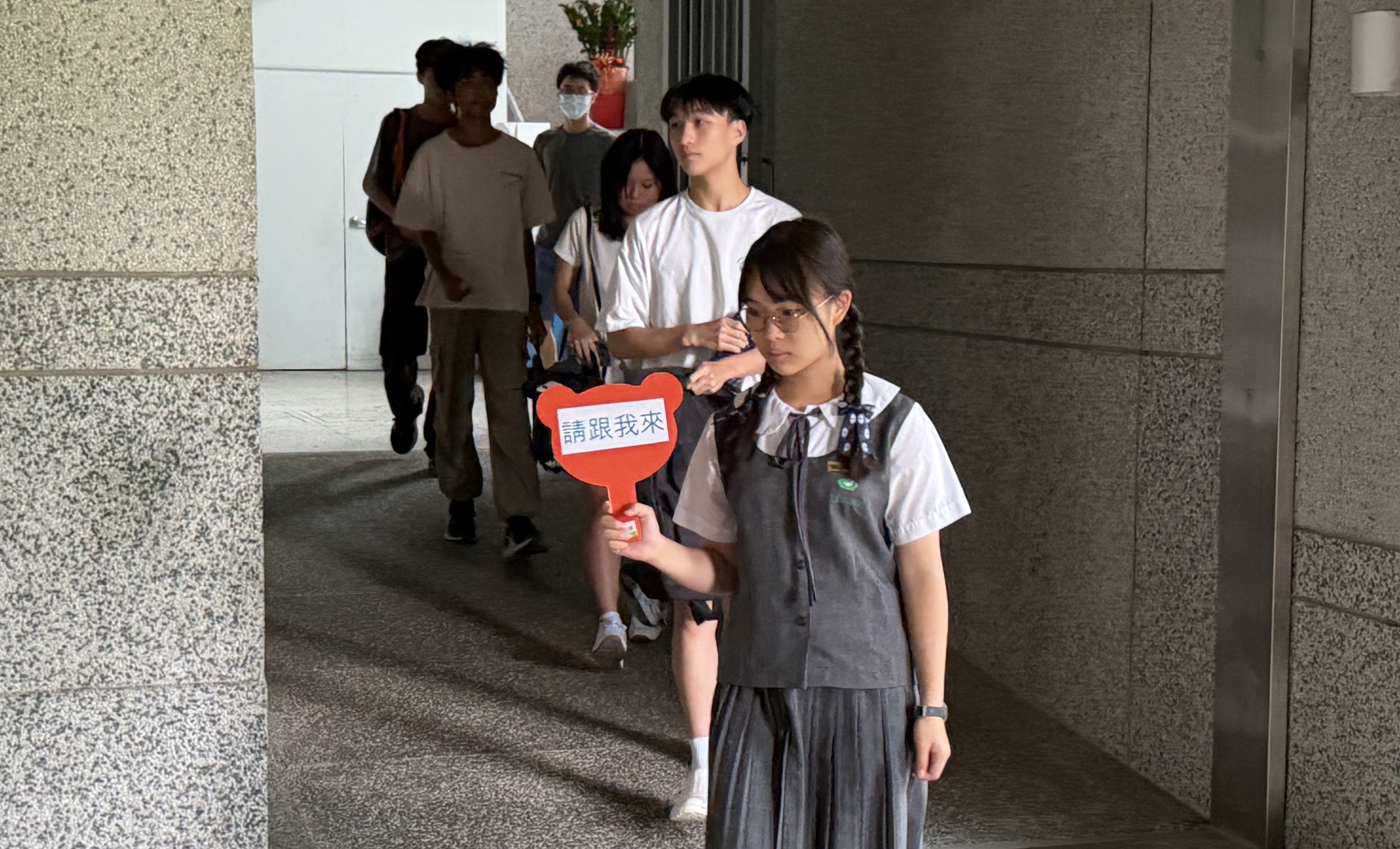 學生志工協助引導考生前往試場。