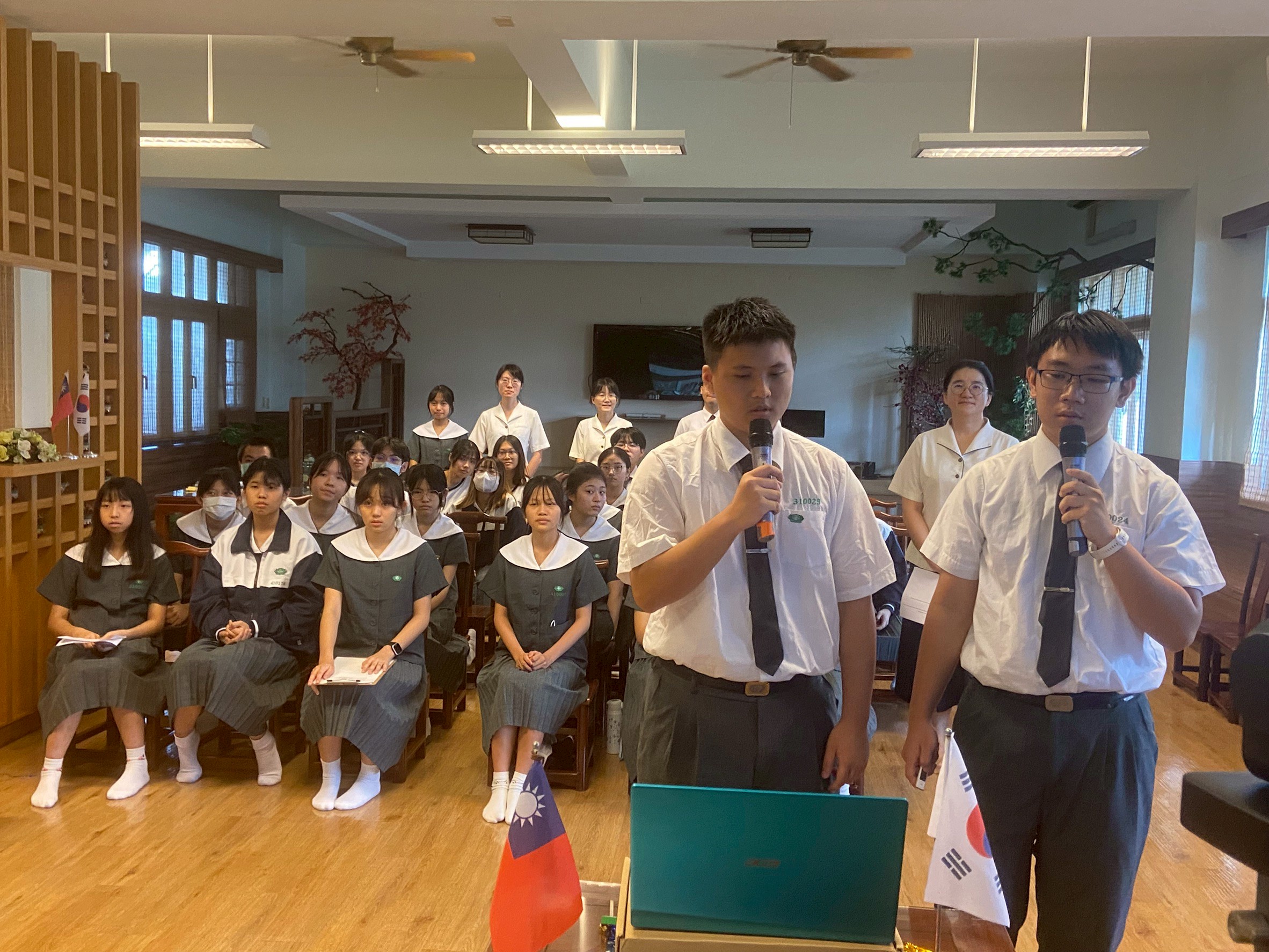 張同學及劉同學用英語簡報介紹臺南慈濟高中。