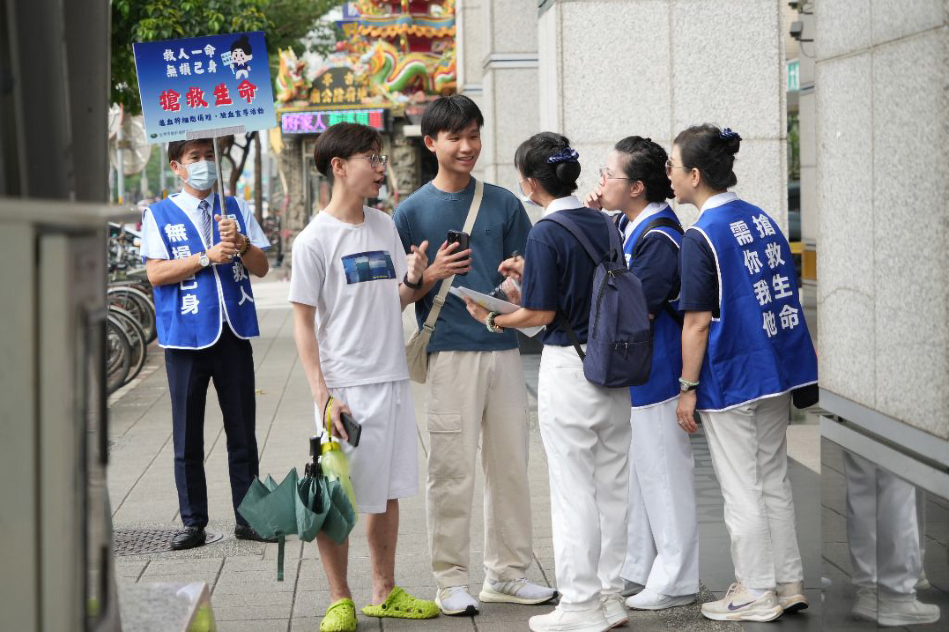 志工在捷運站,耐心向路人解說,希望能邀請更多年輕人挽起袖子,參加造血幹細胞捐贈驗血建檔,幫助血癌患者尋找配對機會。