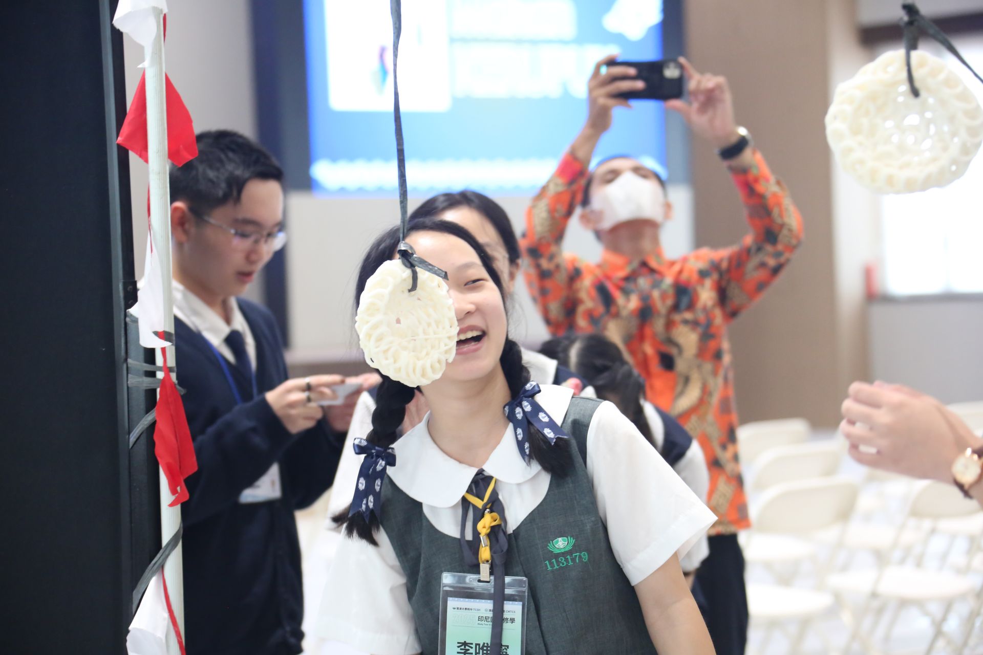 適逢印尼國慶日,同學們體驗「吃脆餅挑戰」(Makan Kerupuk ),不靠雙手,品嚐吊在繩子上的脆餅