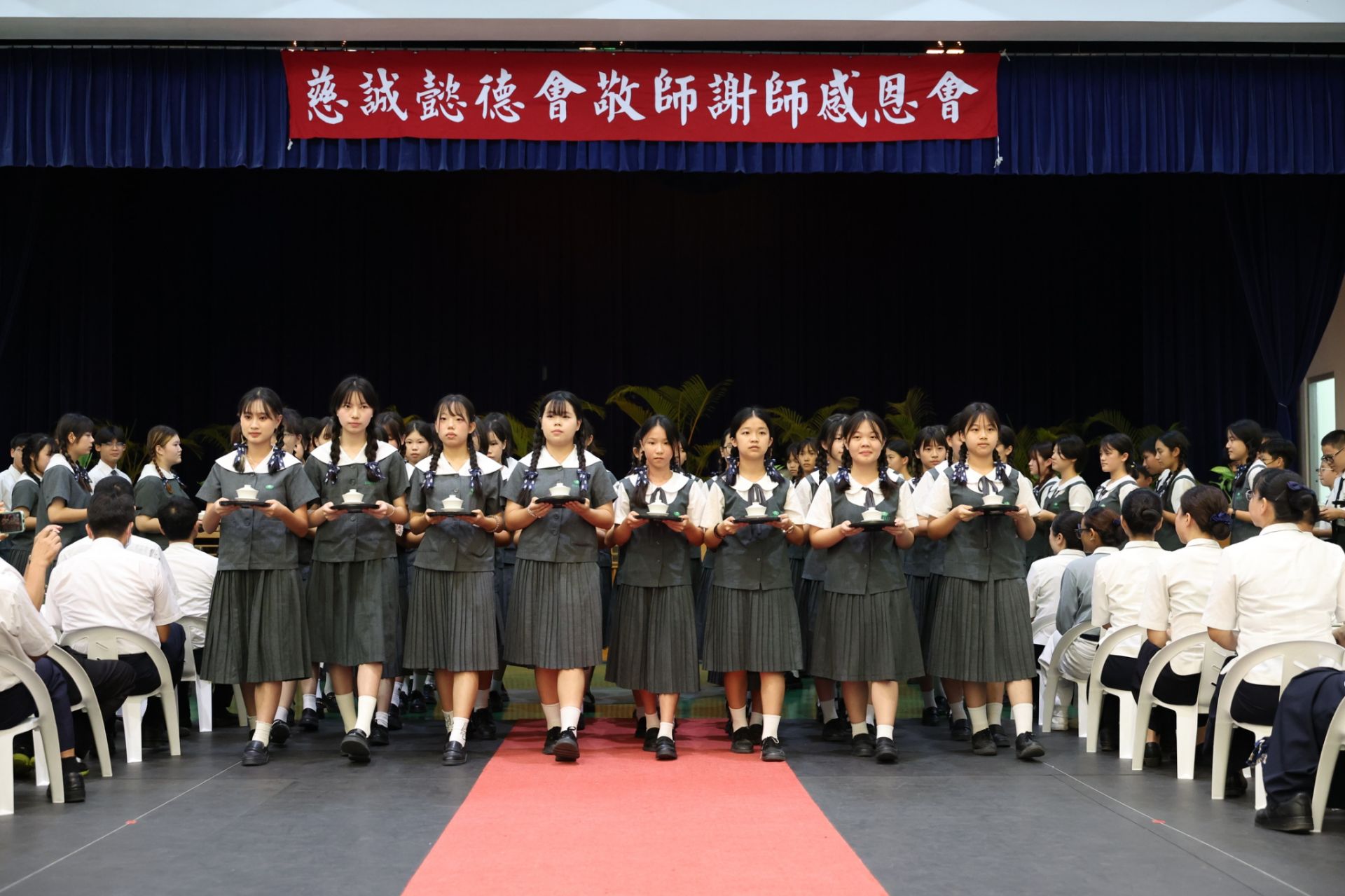 學生慎而重之,踏著一致的步伐,將手中一杯杯無聲的感恩奉給師長