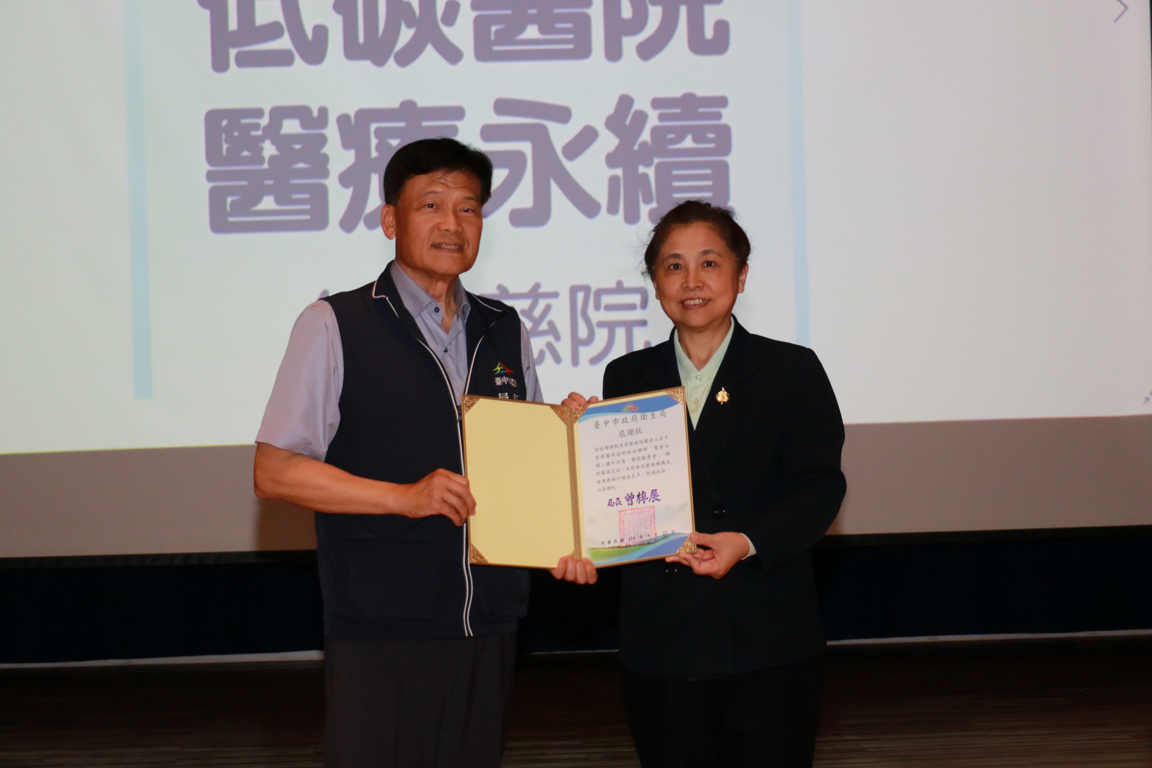 台中市衛生局局長曾梓展(左)頒發感謝狀,由莊淑婷副院長(右)代表台中慈濟醫院接受。