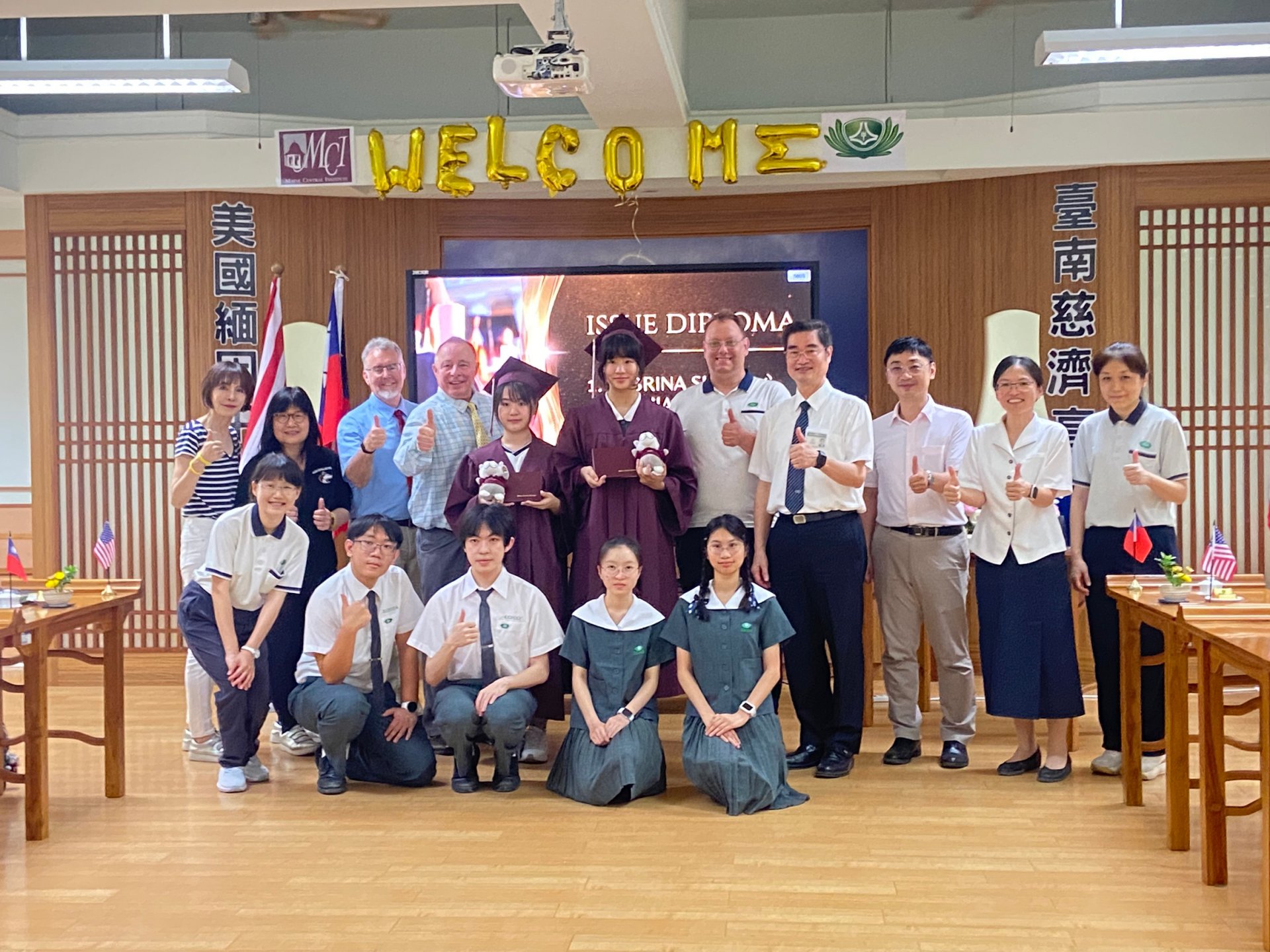 MCI雙聯畢業生身著學士服,手持證書,兩校代表共同合影,展現跨國教育成果。
