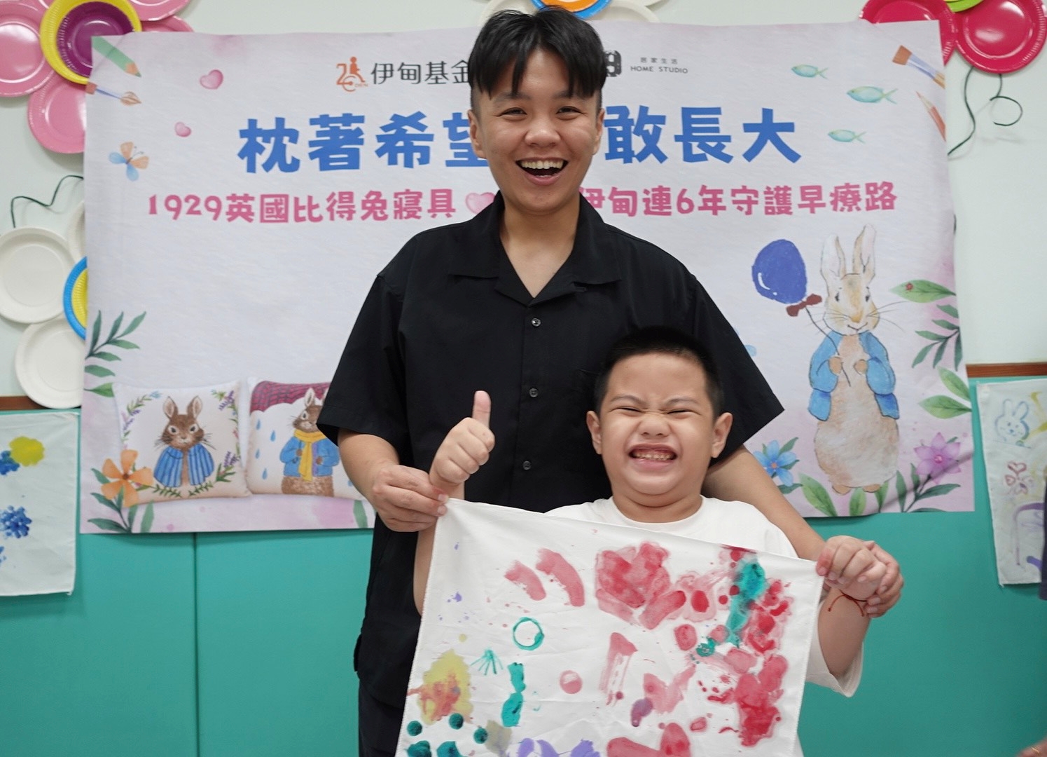 執行長與慢飛天使元元開心合照，自信展示枕頭彩繪成果。