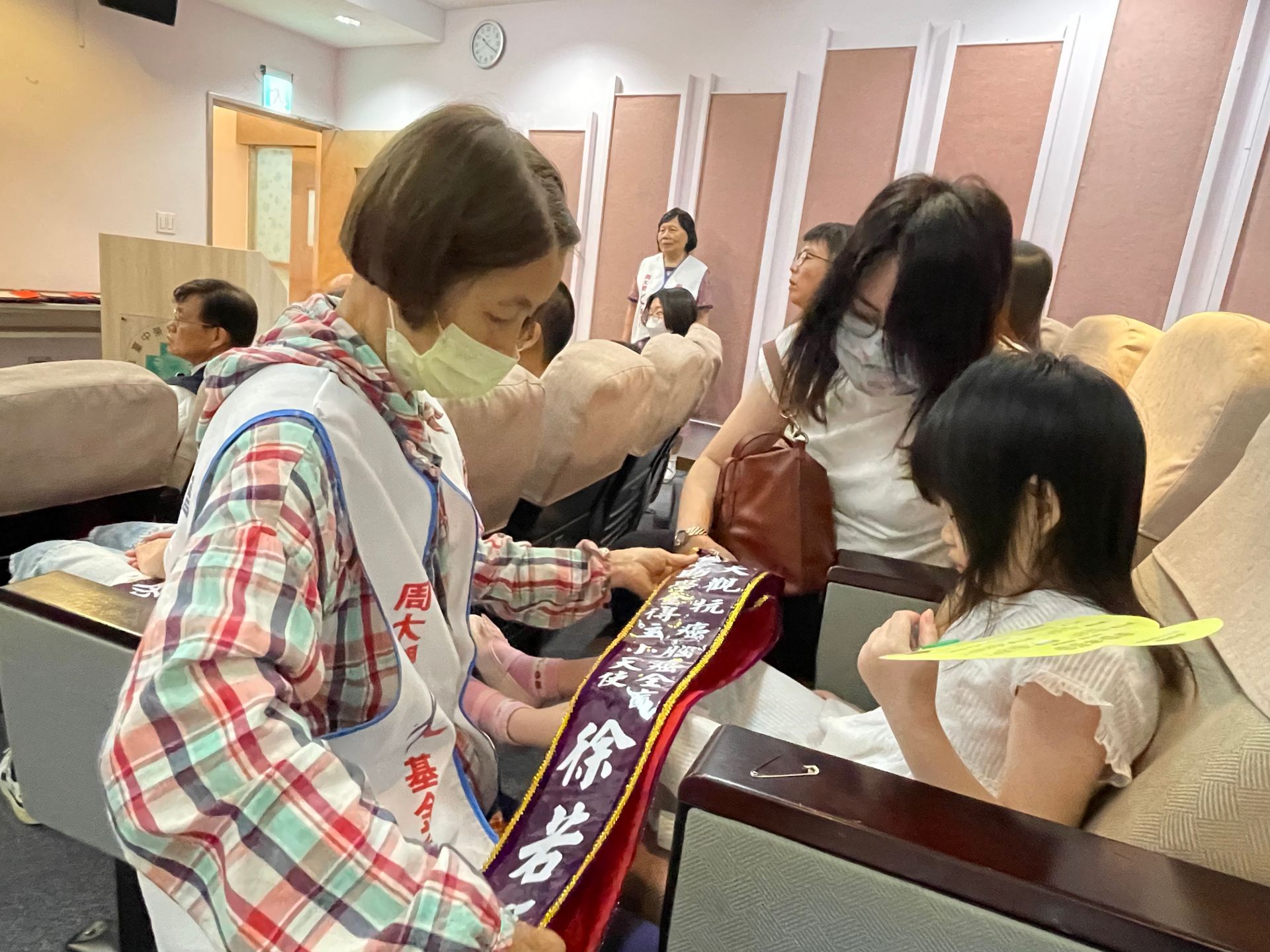 周媽媽為獲獎學生戴背帶