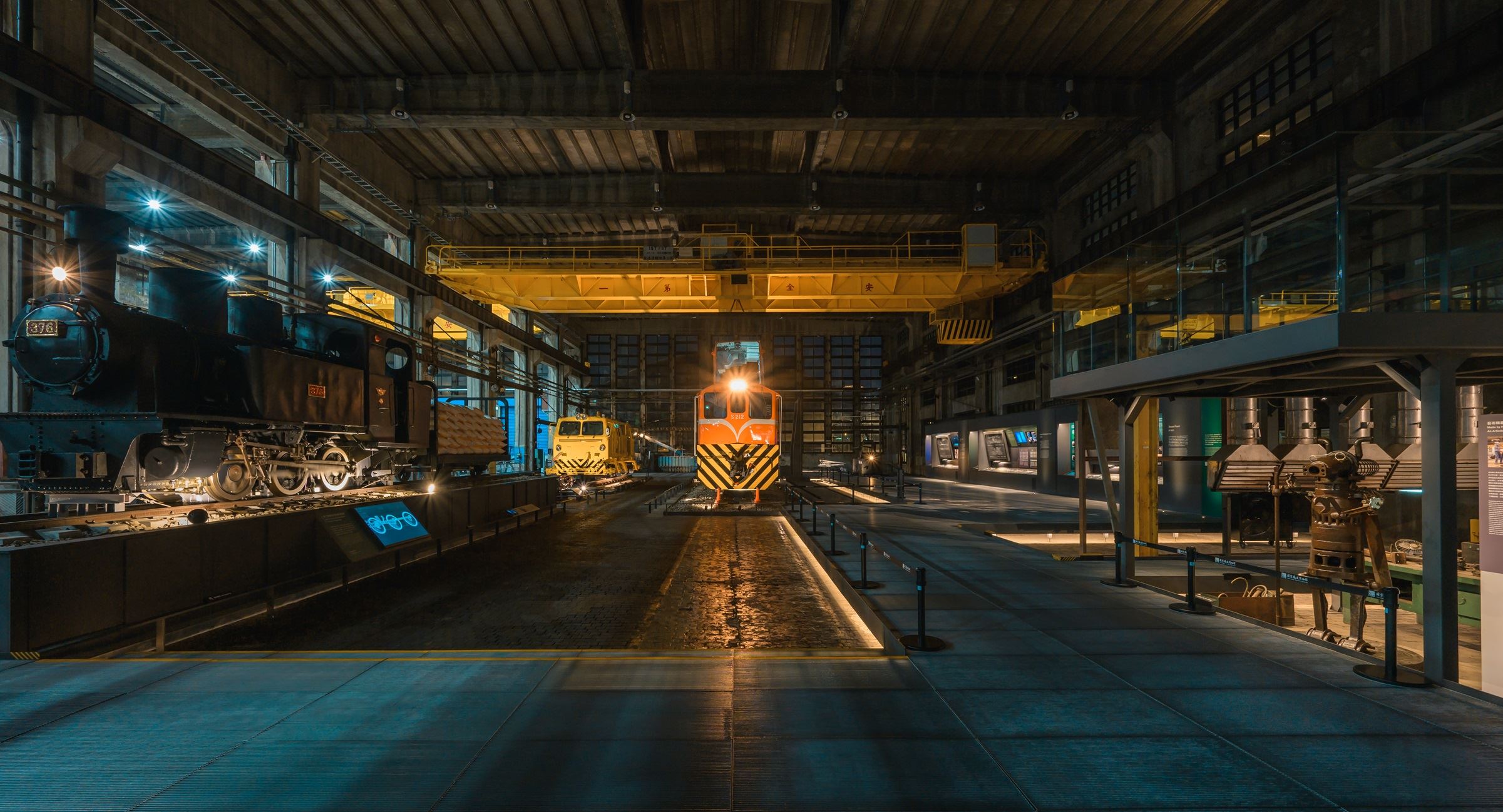 夜間燈光映照下的柴電工場展場,展現車輛、機具與展示空間交織的夜間風貌。