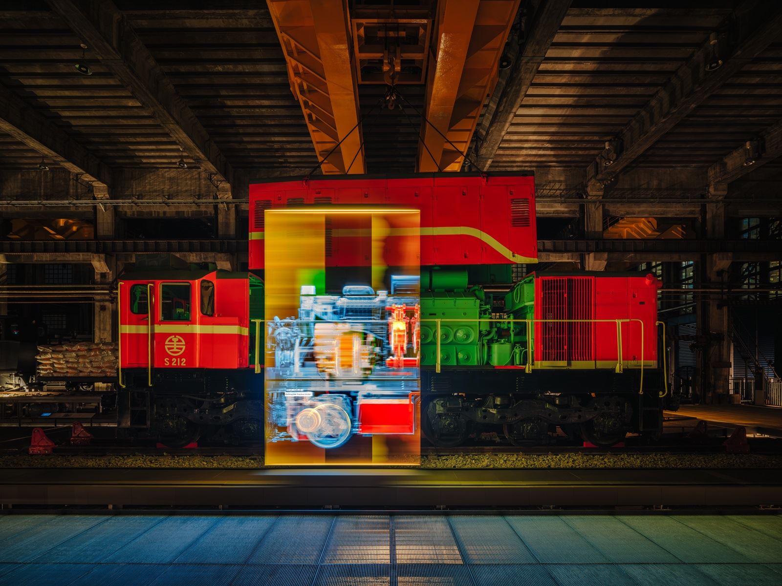 夜間燈光與展示影像映照S212號柴電機車,呈現車輛與工場展演結合的視覺效果。照片提供:當若科技藝術。