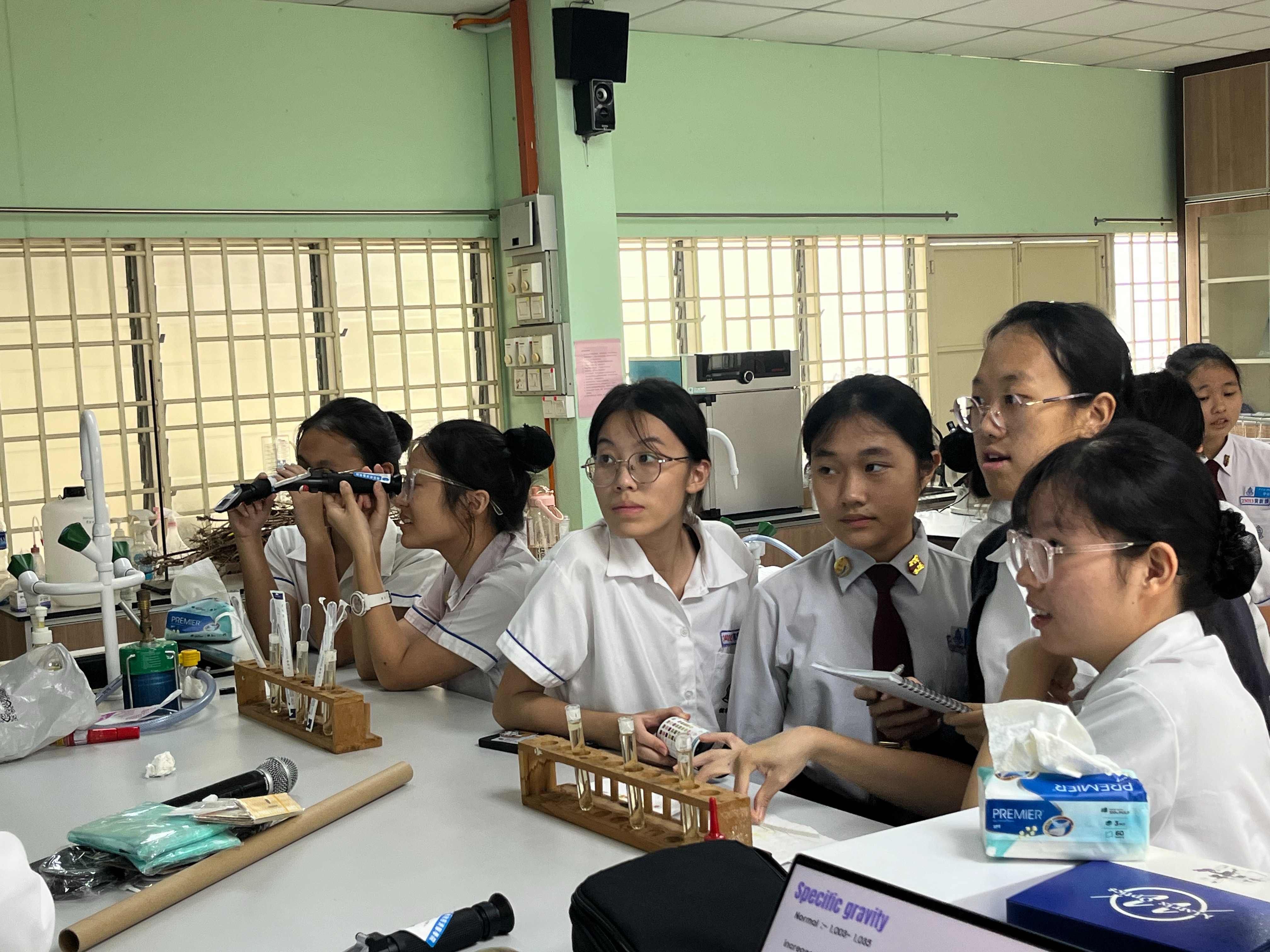 學生們透過尿液試紙進行尿液檢測，仔細觀察各項指標的顏色變化。