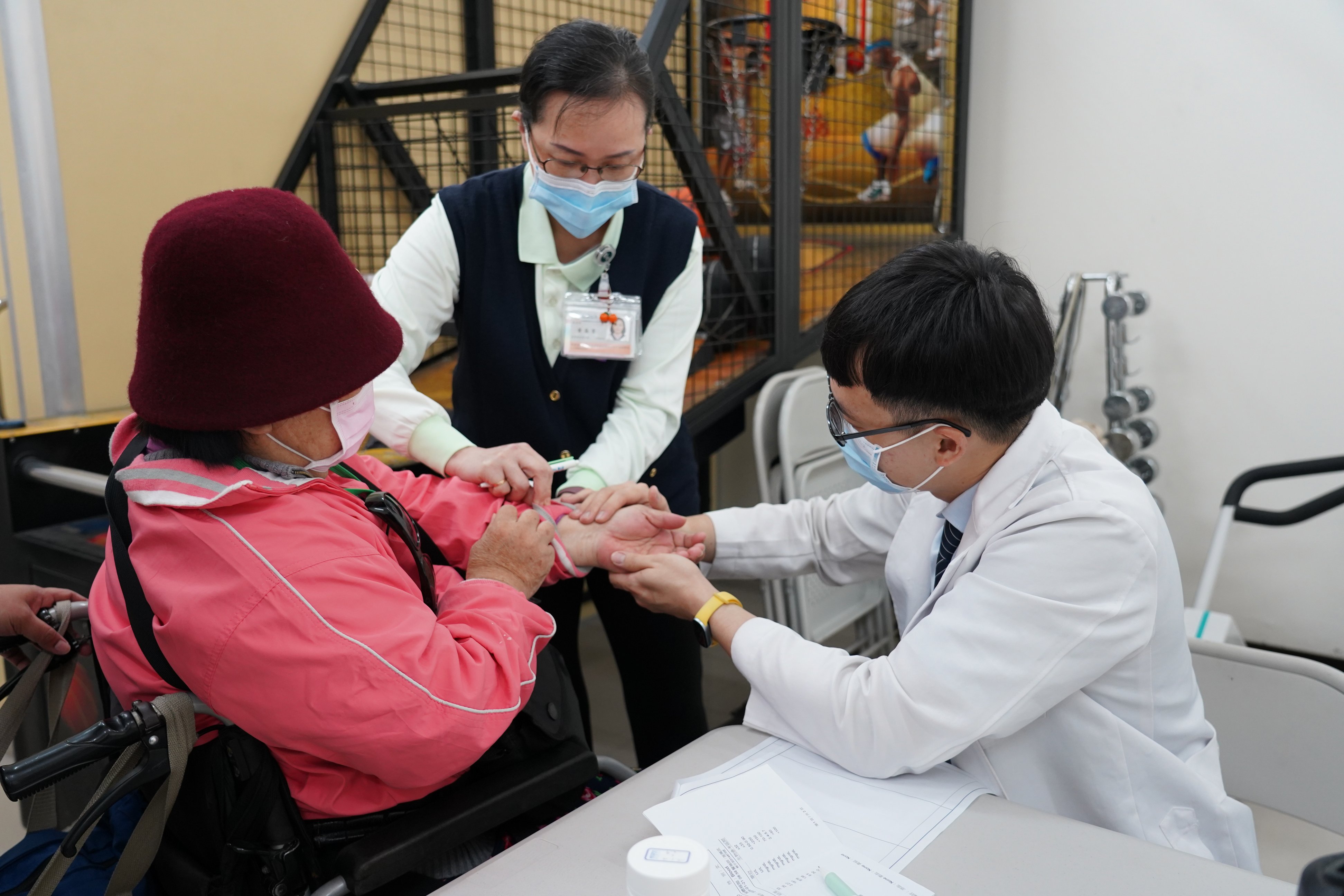 中醫部醫師洪正君（右）透過脈診與針灸為傷友調理體質，協助舒緩因脊髓損傷帶來的肢體僵硬與不適。