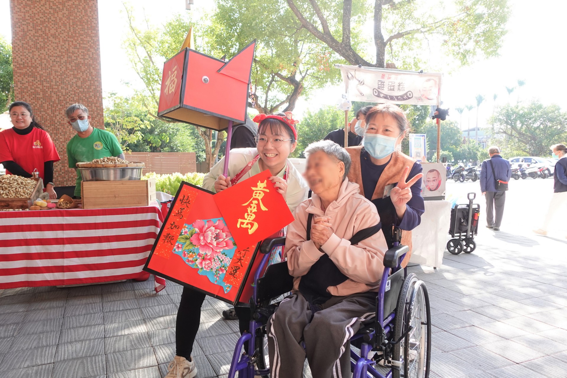 機構人員穿著喜氣的「福氣馬」造型裝飾,帶住民長輩逛街採買、發送春聯給各攤位。