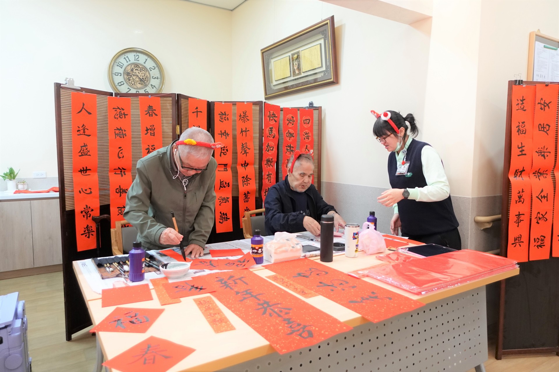 張爺爺(左二)過去是鄰里間知名的書法好手,他展現筆墨功力,神采奕奕的寫吉祥話。