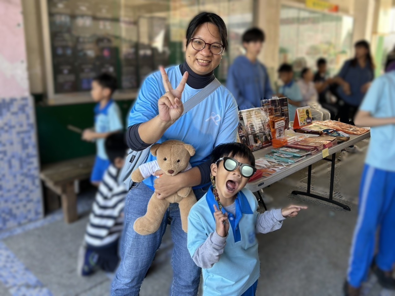 校慶當天,台灣世界展望會設攤服務,曾受助的怡琴主動分享成長故事,並與兒子在攤位前合影,感謝一路陪伴她走過童年的支持。