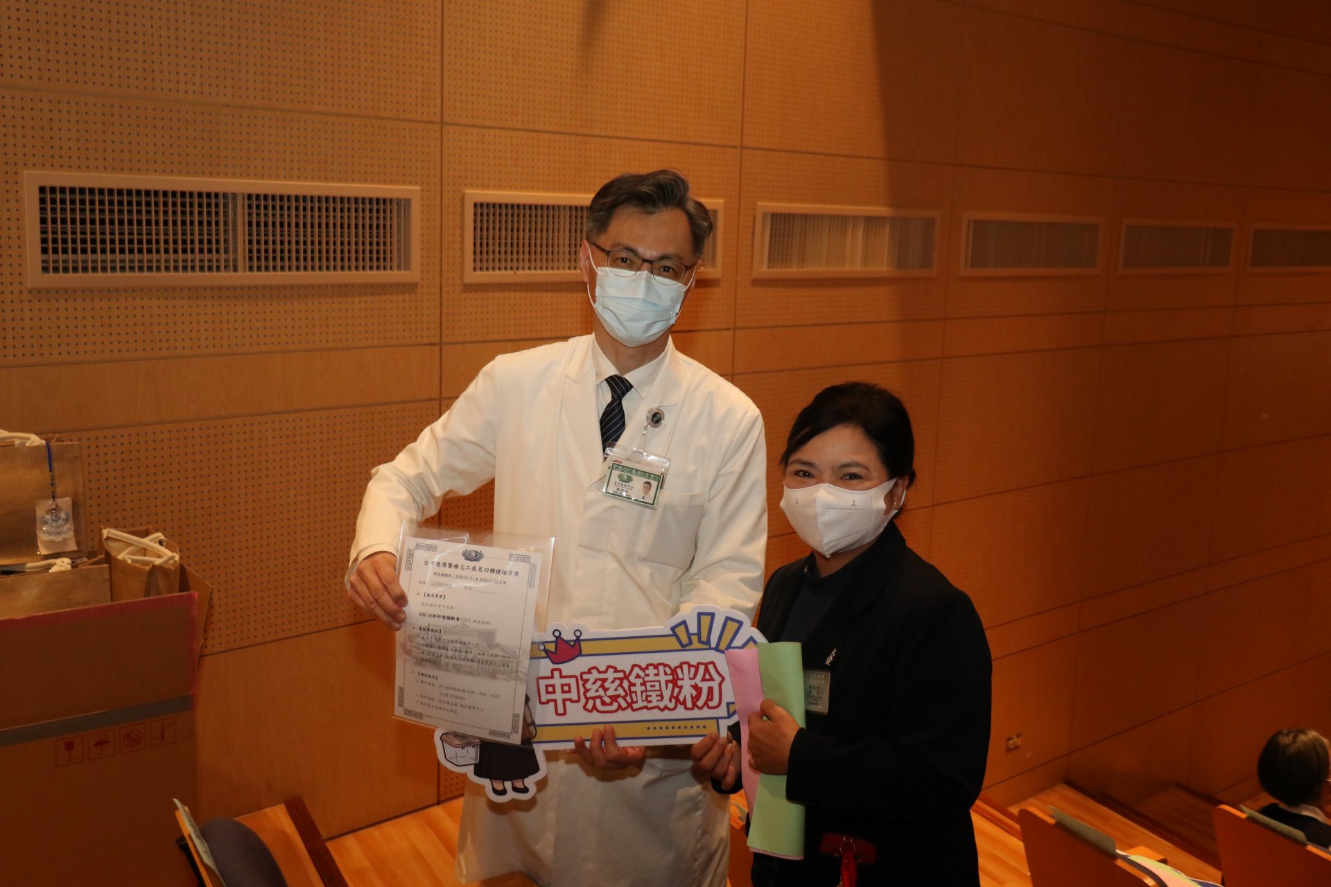 「誰最瞭解台中慈院」互動遊戲選出優勝志工,由外科部主任鄭紹彬(左)送上高階影像檢查資格,回饋志工的付出。