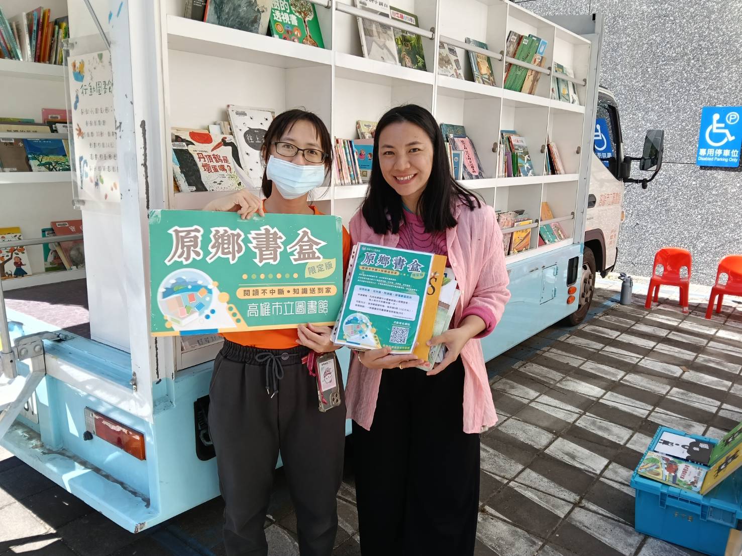 1150204那瑪夏圖書館 (48)高市圖館員於行動書車前向民眾推廣「原鄉書盒」閱讀服務,介紹免費到宅送書資源,讓閱讀深入原鄉社區,縮短城鄉閱讀資源落差。