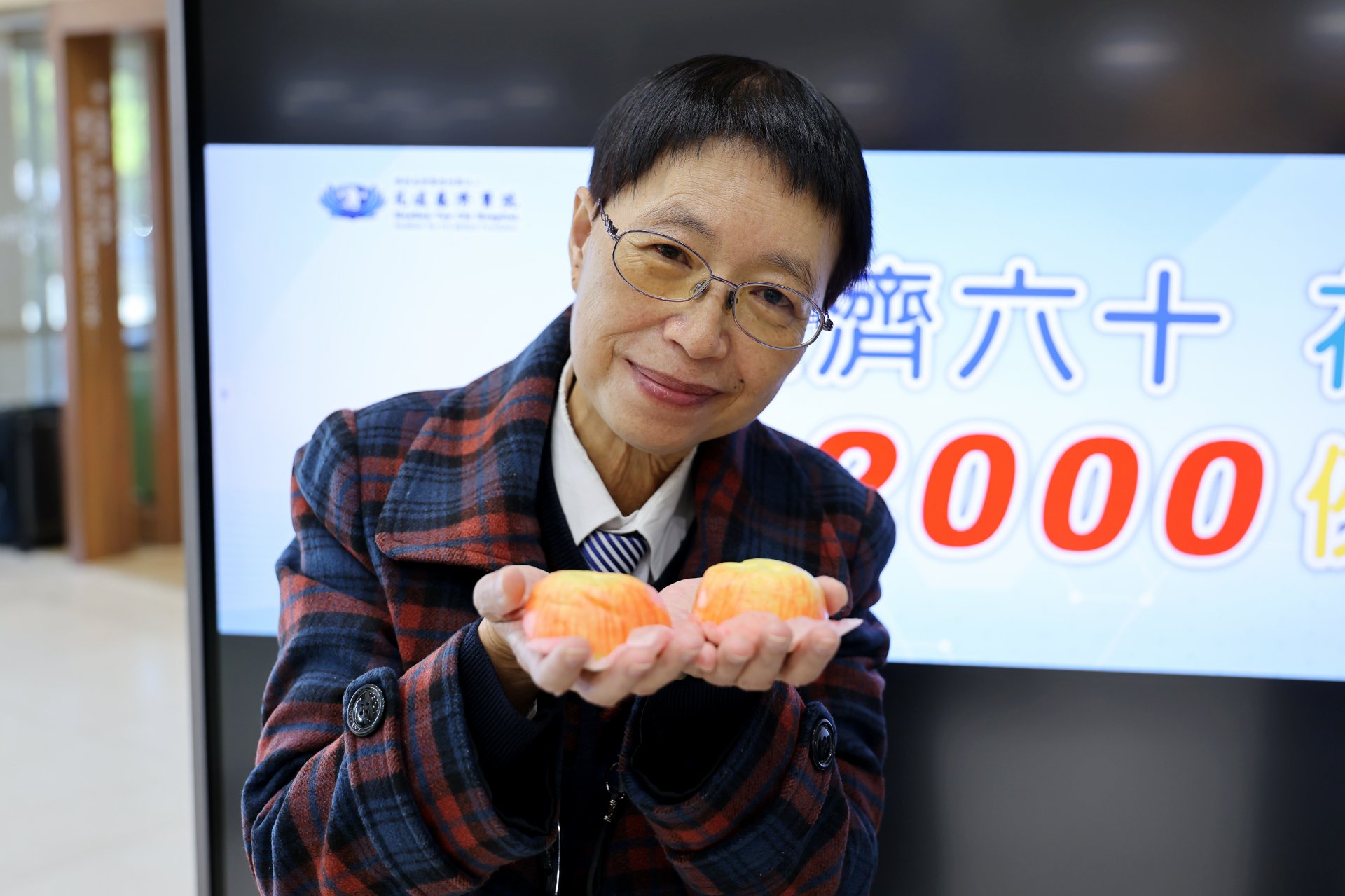 陳惠玲拿著院方送給她象徵平安的蘋果包,以23年的治療歷程,鼓勵所有病友相信醫療團隊,也感恩可以在花蓮獲得治療重拾健康,回歸社會。