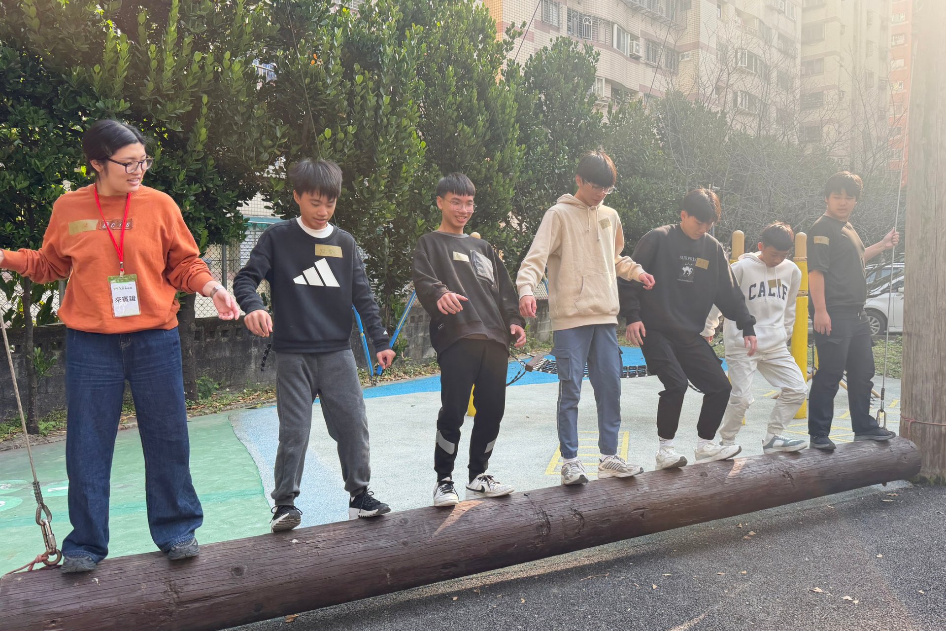 青少年透過默契合作，挑戰一起站在平衡木上