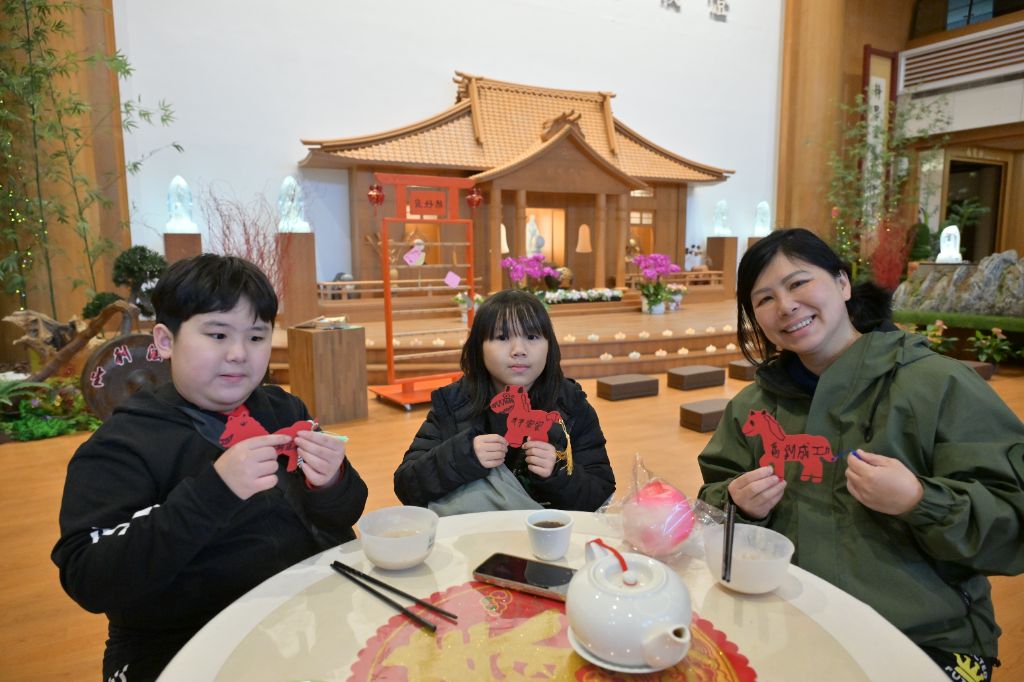 傅女士(右一)帶著二位侄子品嚐平安粥,也常帶他們參加慈濟活動,希望能多認識慈濟人文,增加品格教育的成長。