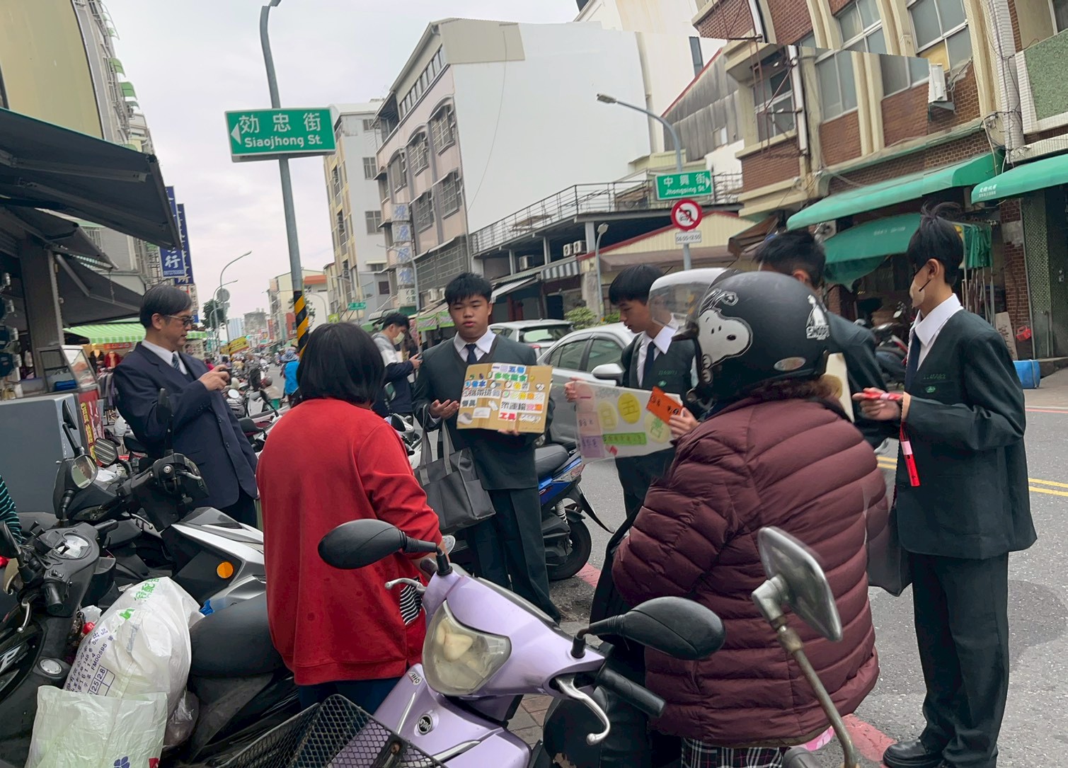 國一同學在生活感十足的安平市場宣揚環保與慈悲大挑戰活動，獲得媽媽們的響應。
