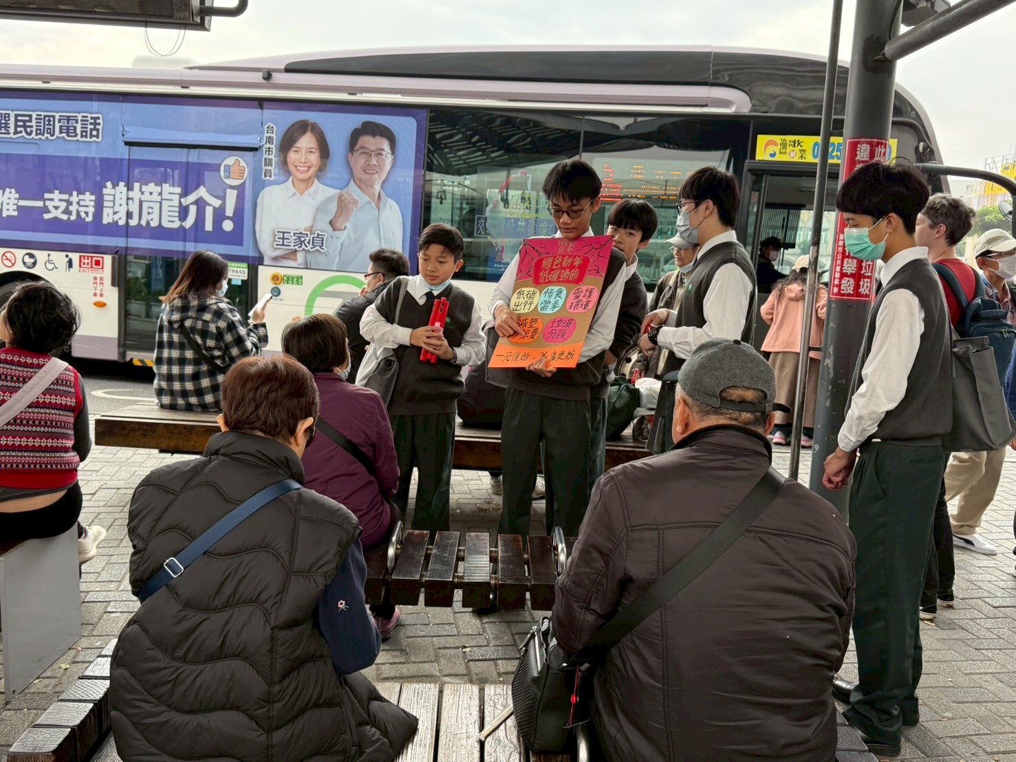 國二同學向等公車的乘客們推廣綠色行動，低碳過節的環保理念。