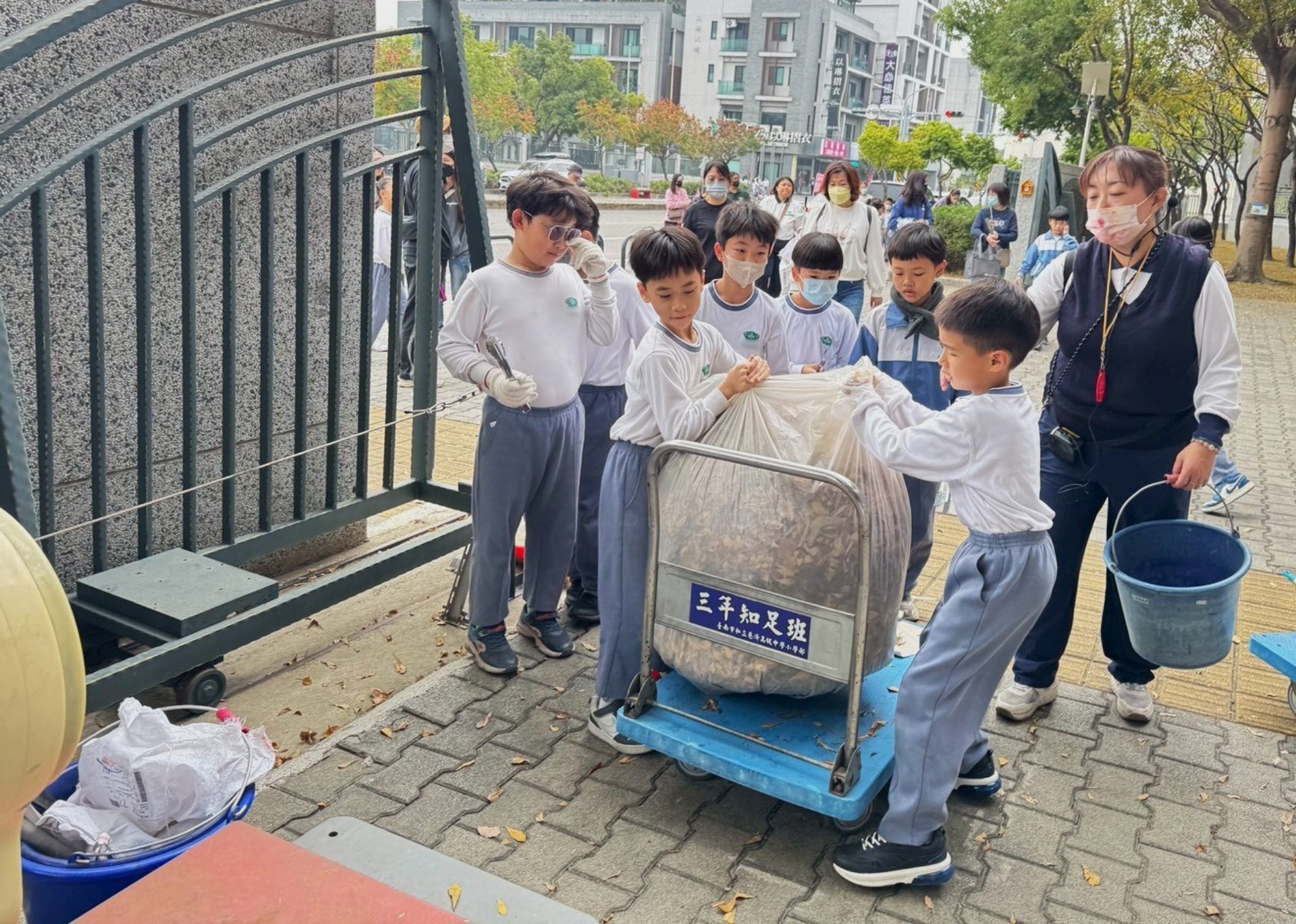 走過大街小巷,孩子們提著大包小包的垃圾回到學校。