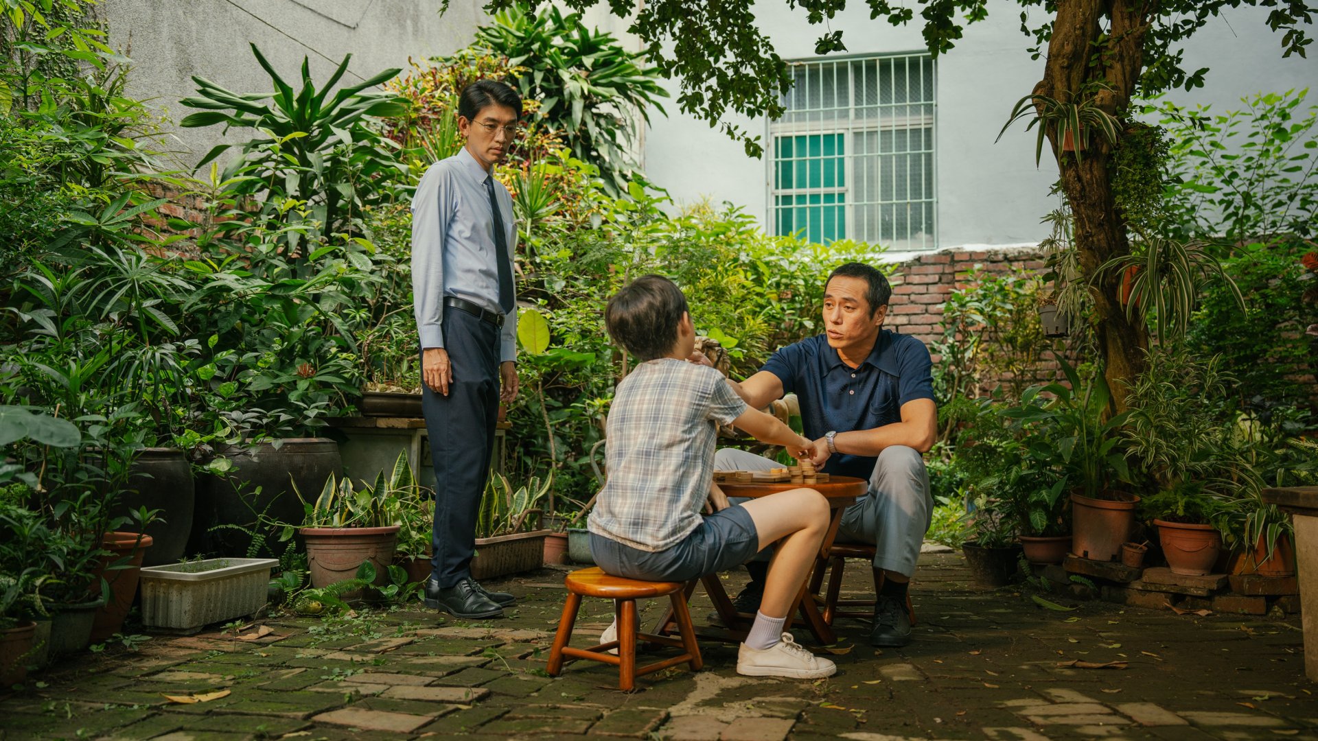 李啟誠(圖左,曾少宗 飾)進入在高雄的舊家,看著父親(圖右,莊凱勛 飾)正藉由象棋教導著年少的自己(圖中,劉曜誠 飾),保持謙虛,小心的走好每一步
