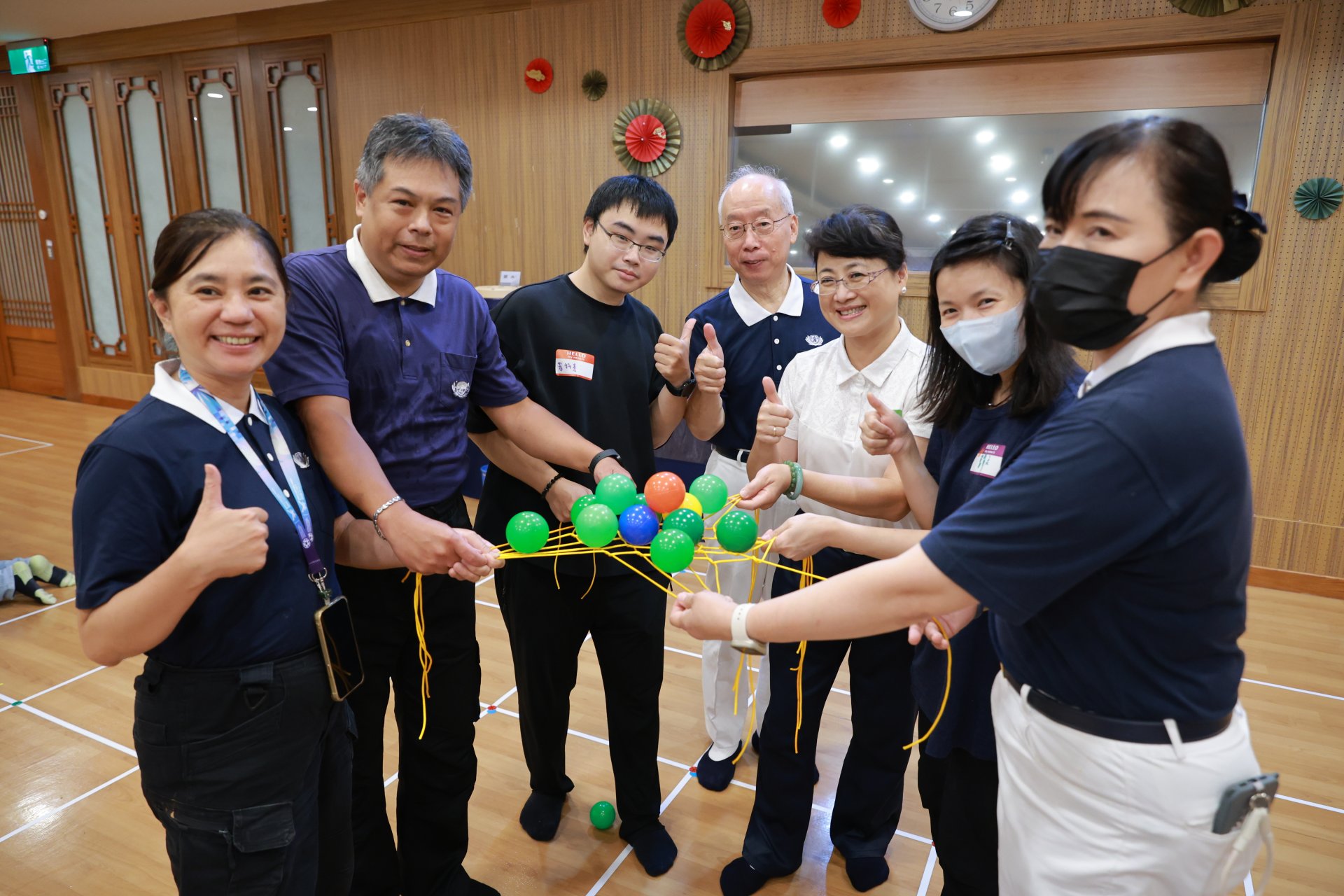 在破冰活動「同心協力」中,各組學員齊心協力拉著黃色交錯的繩網,小心翼翼地維持平衡,設法不讓網上的彩色顆粒球落下,現場驚呼聲與歡笑聲不斷,快速建立起團隊目標與革命情感。