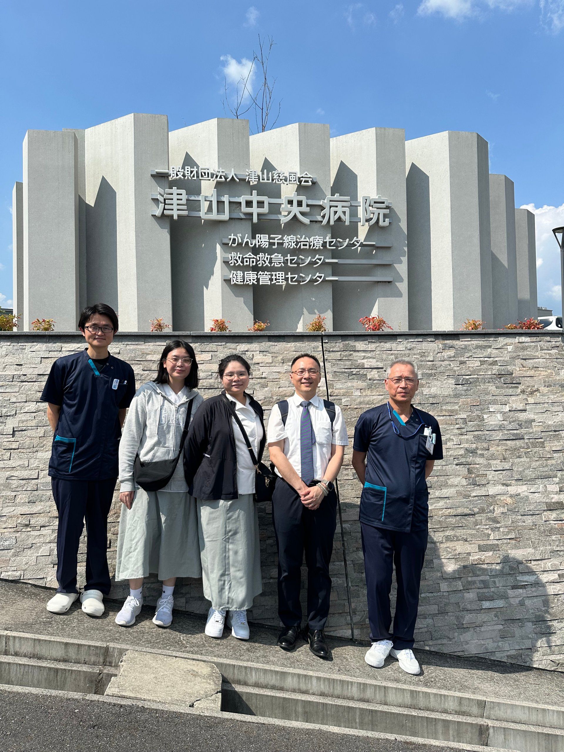 與津山中央病院放射部門松田哲典部長及張智凱放射師合影於該院門口