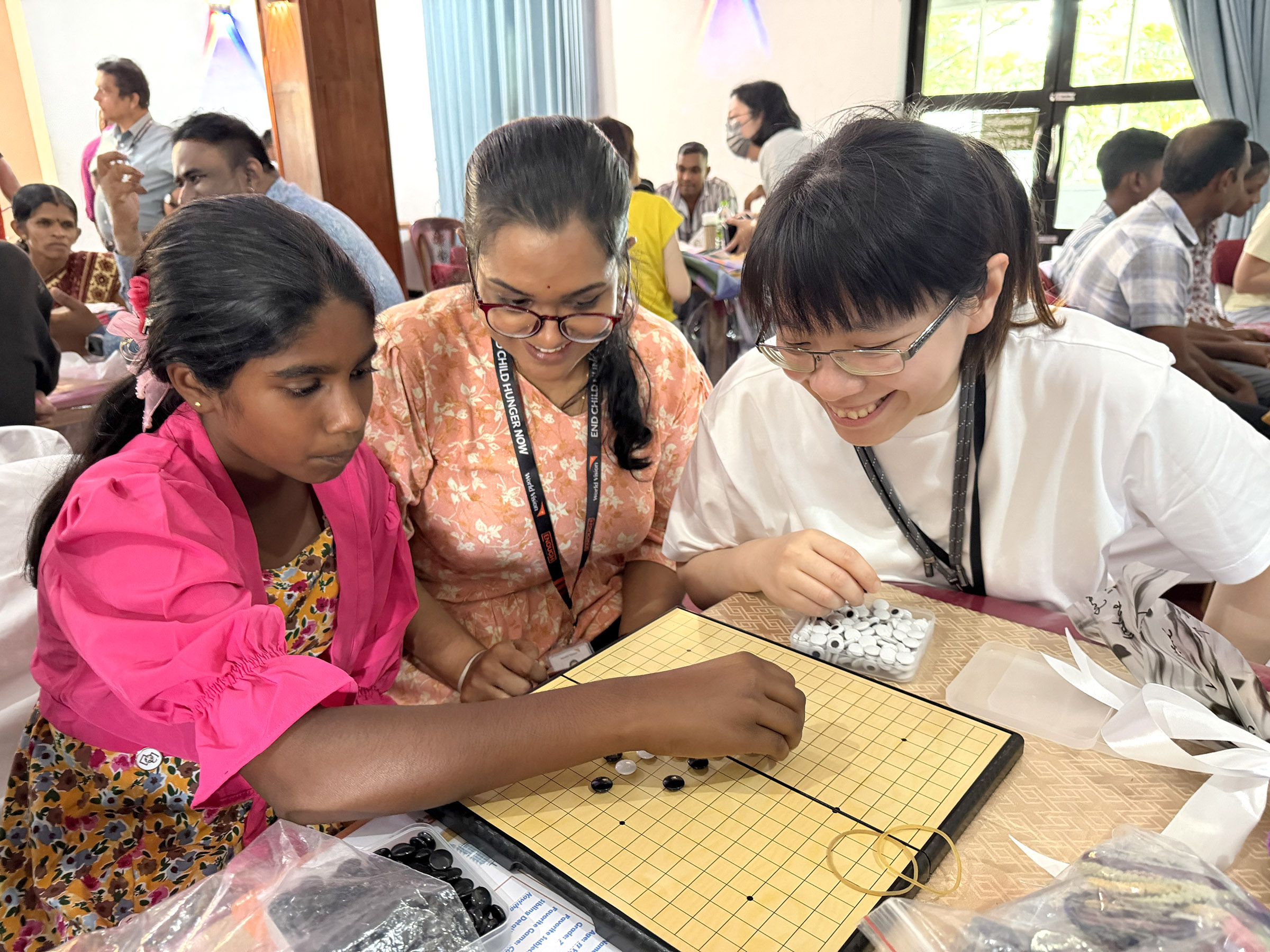 資助人黃映蕙仔細觀察資助童薩烏麗(Savuli)的喜好,帶了五子棋和棋盤,並現場教學,笑說:「她學很快!」
