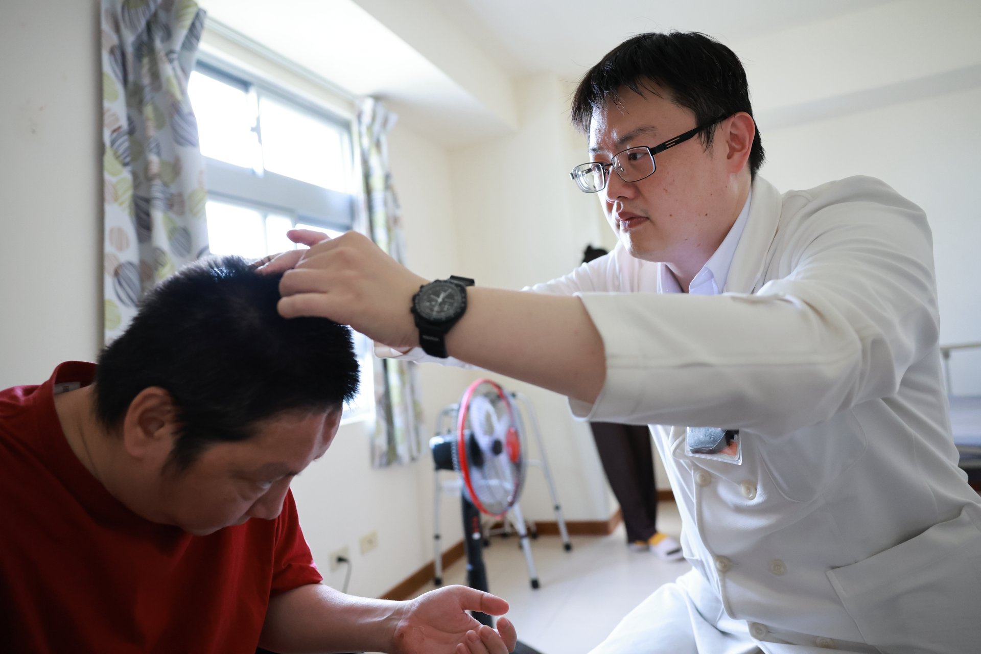 花蓮慈濟醫院中醫部副主任陳中奎到阿虎家中,為阿虎進行居家中醫治療。