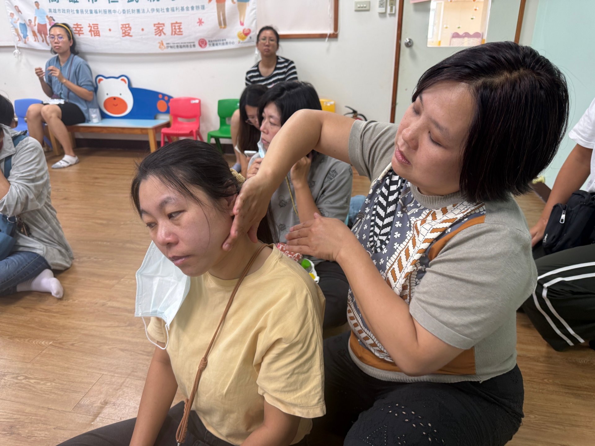 課堂中蔡佳瑋講師教導家長們如何互相按摩肩頸,藉此紓解平日照顧家庭的壓力。